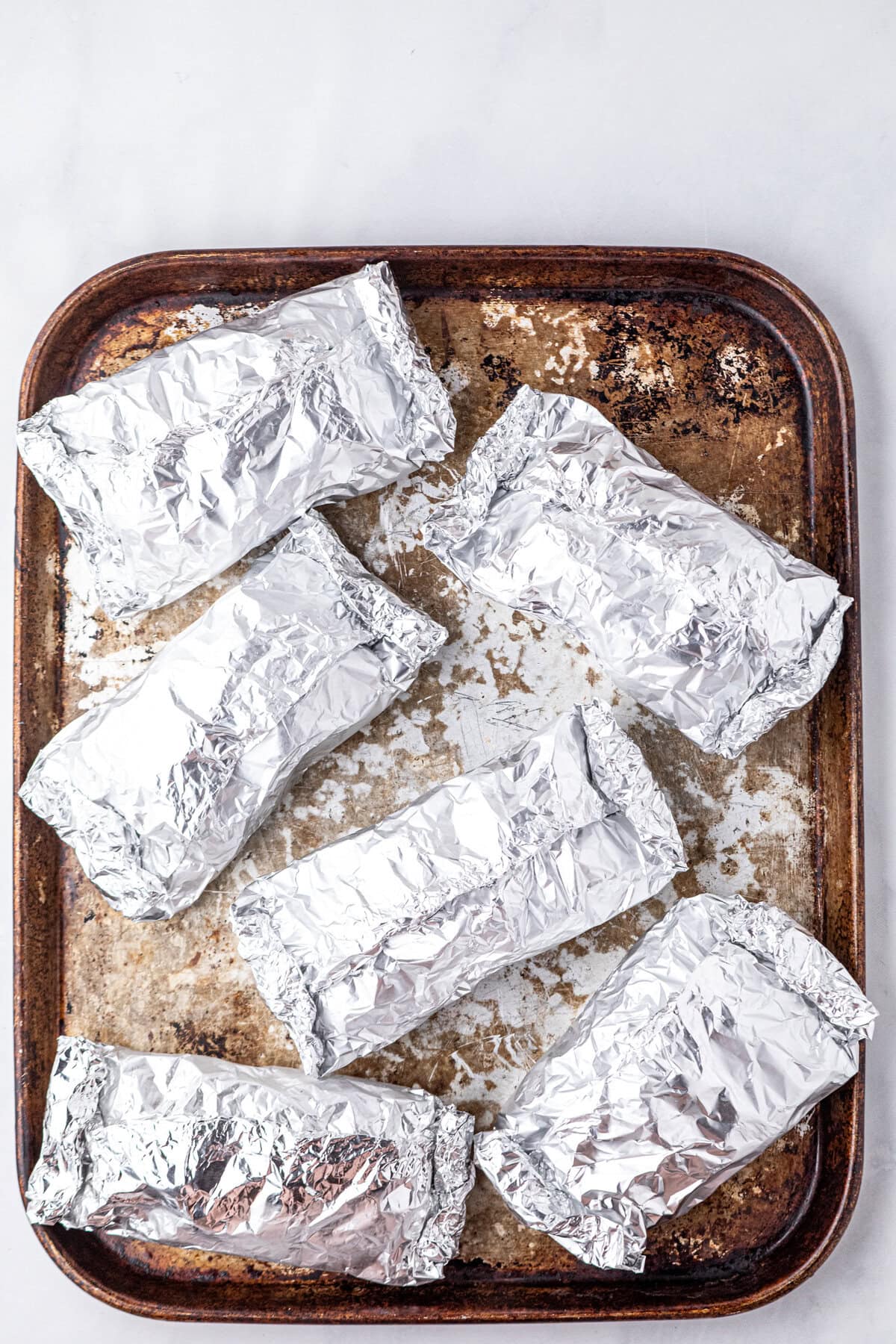 Wrapping Crack Chicken Foil Packets and arranging them on cooking sheet