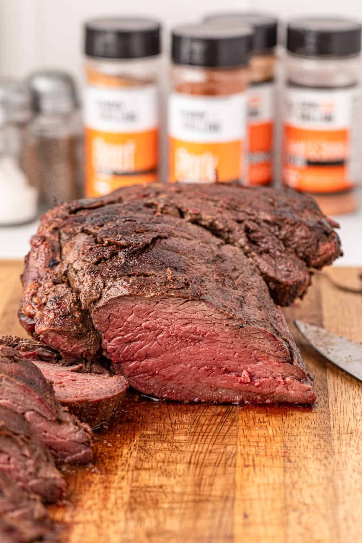 Slicing Smoked Beef Tenderloin into 1" pieces on wooden cutting board