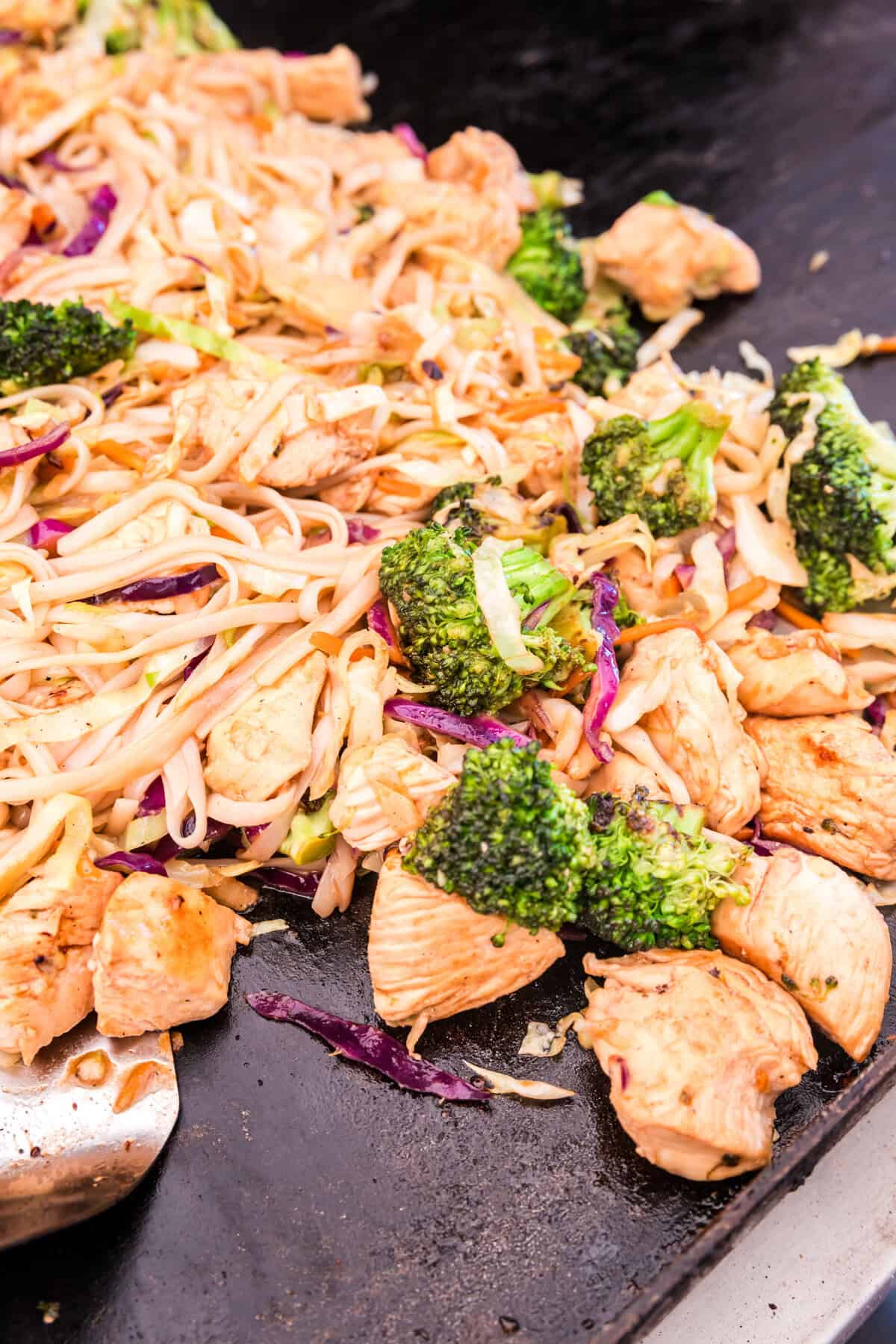 Tossed ingredients on griddle for Blackstone Chicken Stir Fry recipe