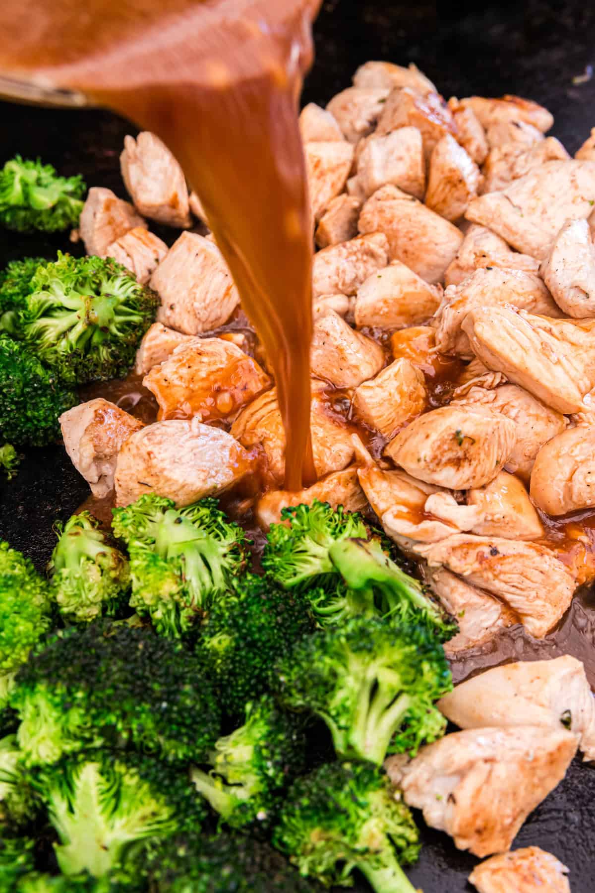 Pouring sauce on Blackstone Chicken Stir Fry