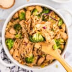 Blackstone Chicken Stir Fry in shallow serving bowl with wooden spoon