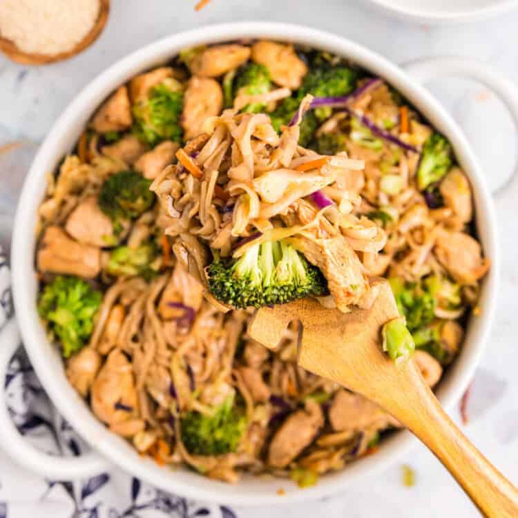 Blackstone Chicken Stir Fry in shallow serving bowl with wooden spoon
