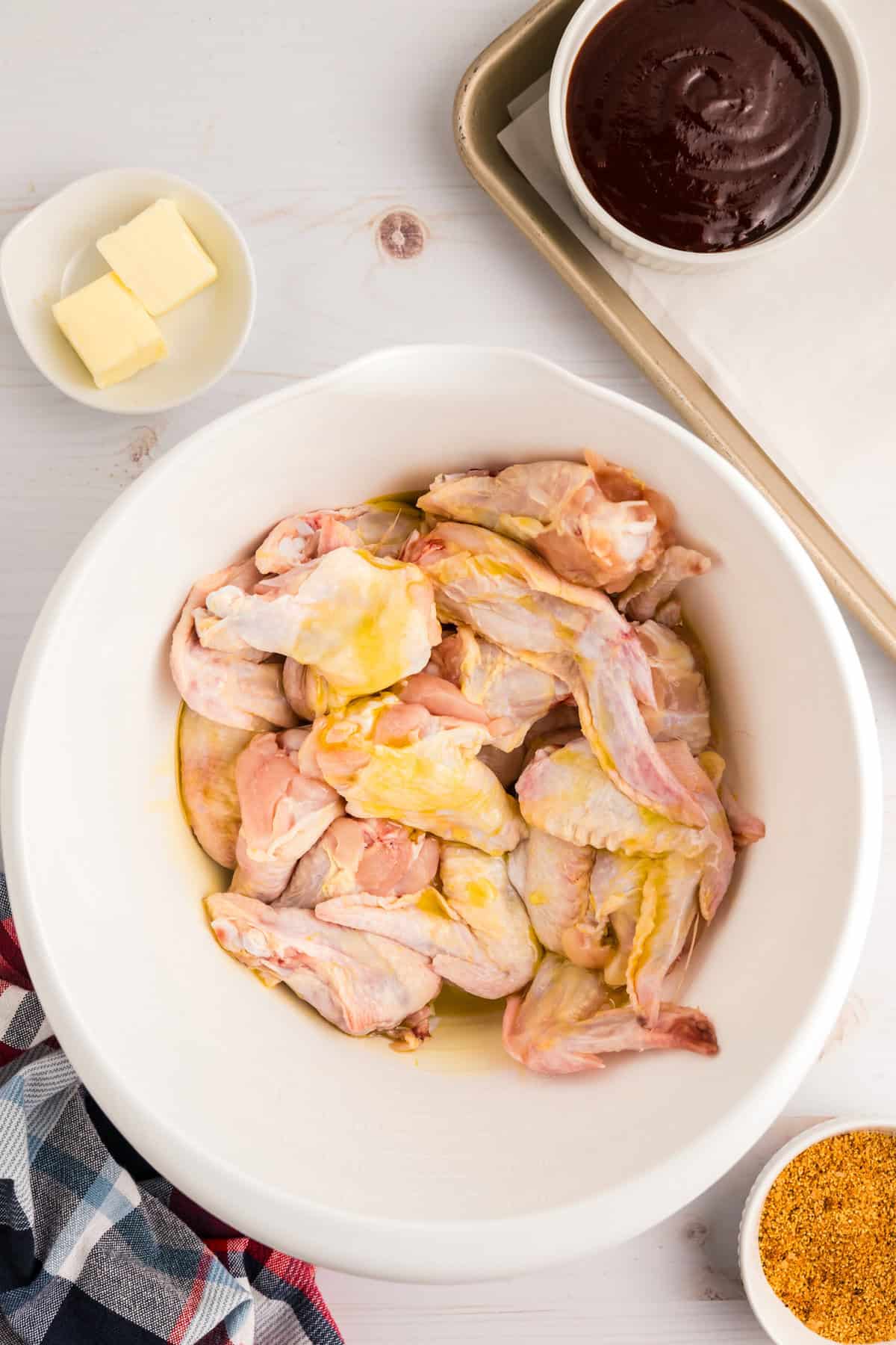 Chicken wings in bowl with olive oil and butter  for Blackstone Chicken Wings recipe