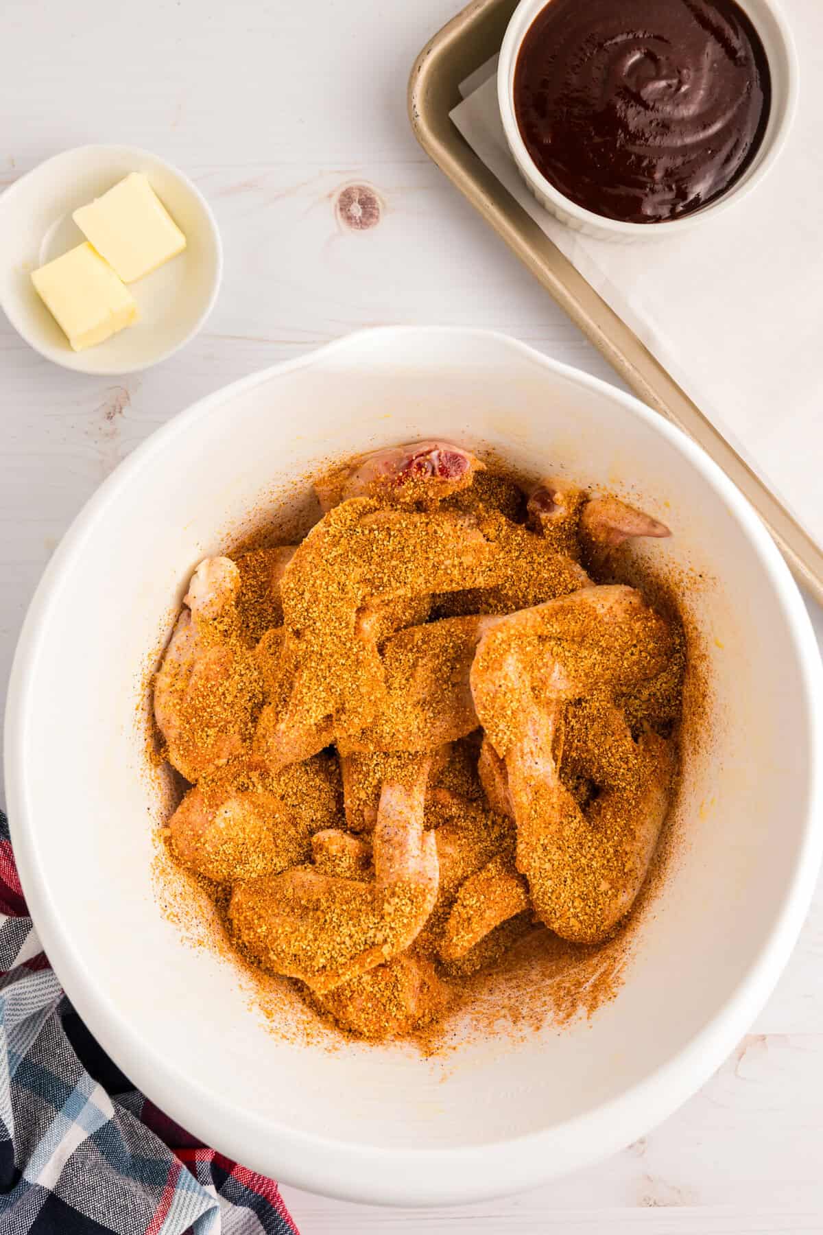 Coating chicken wings with BBQ rub in bowl for Blackstone Chicken Wings recipe