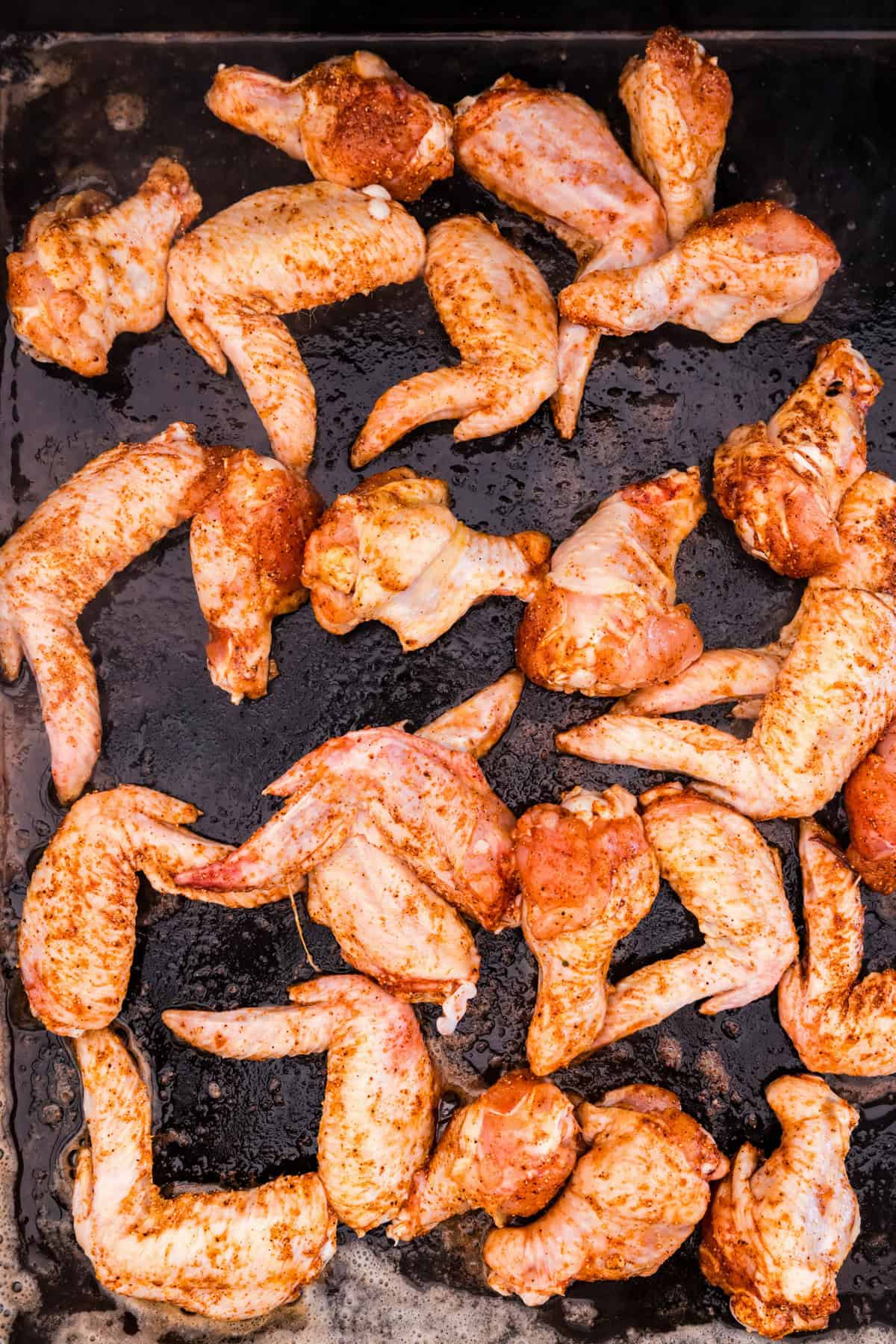Seasoned chicken wings on griddle for Blackstone Chicken Wings recipe