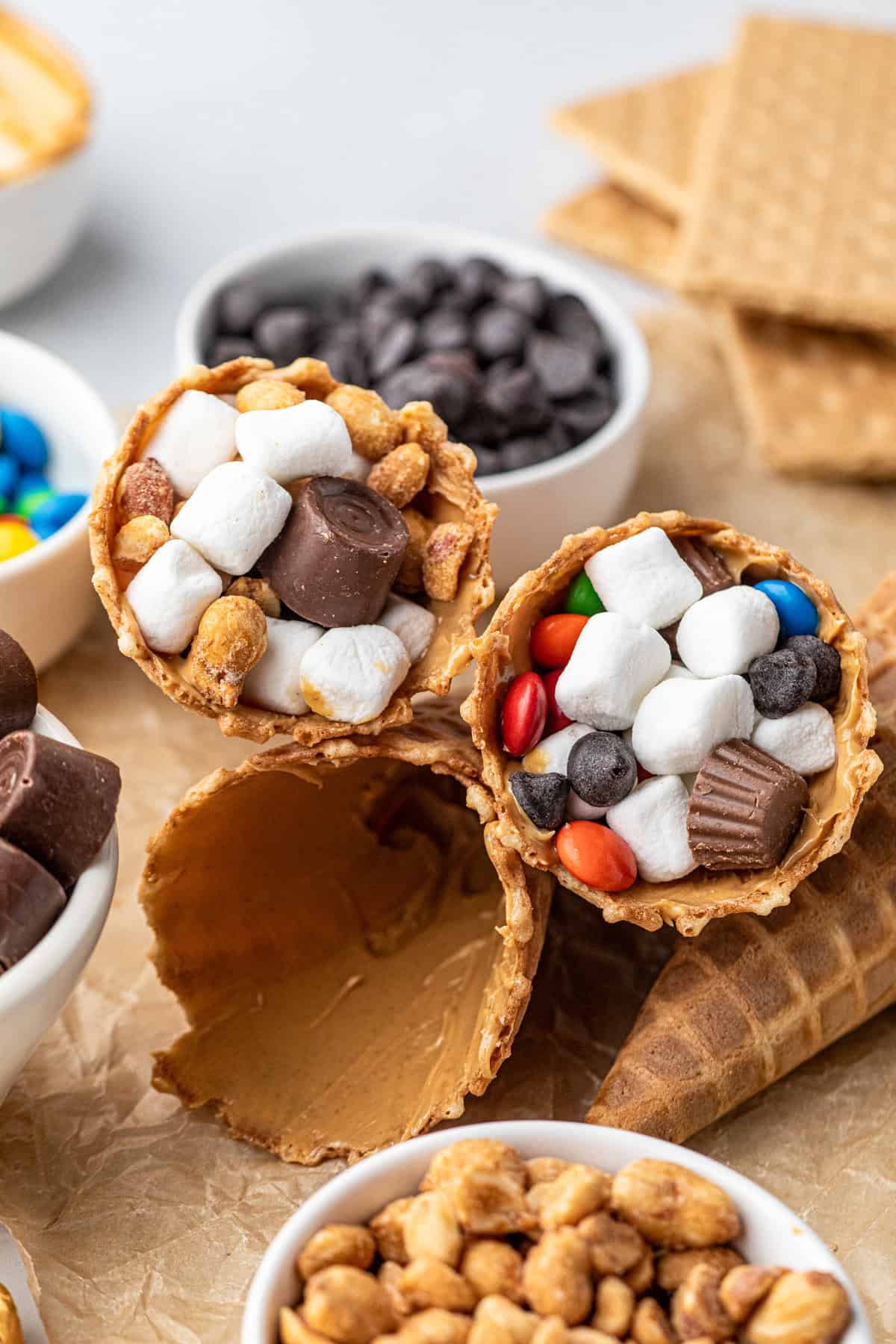 Smeared peanut butter in waffle cone stuffed with fillers for Campfire Cones on the grill