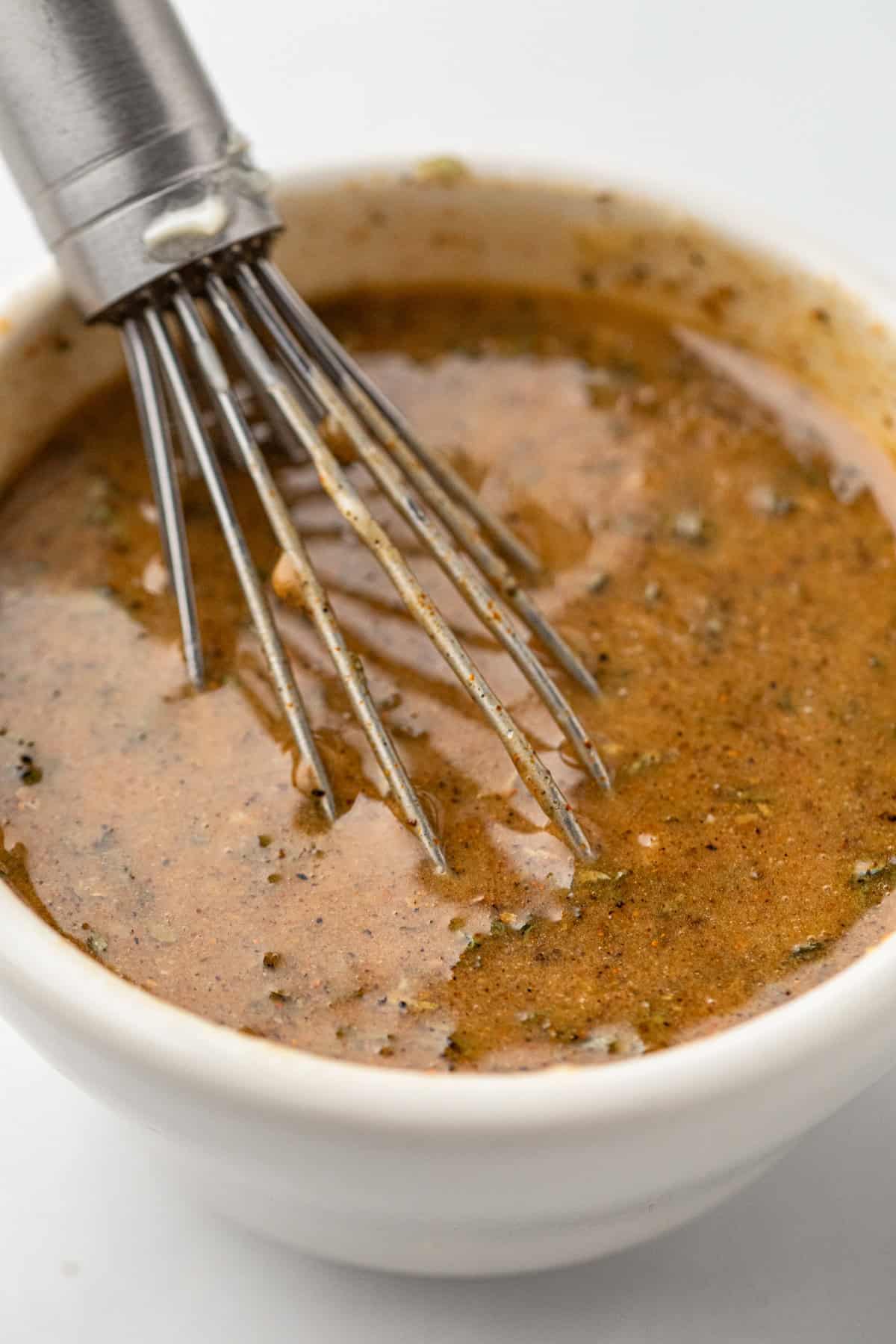 Whisking butter and seasoning mixture in small bowl for Shrimp Boil Foil Packets