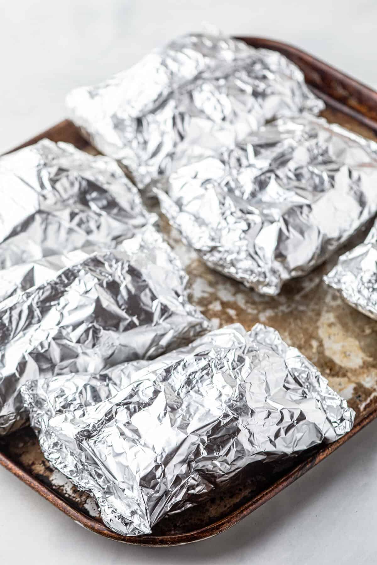 Wrapping Shrimp Boil Foil Packets in tinfoil and arraning on cooking sheet