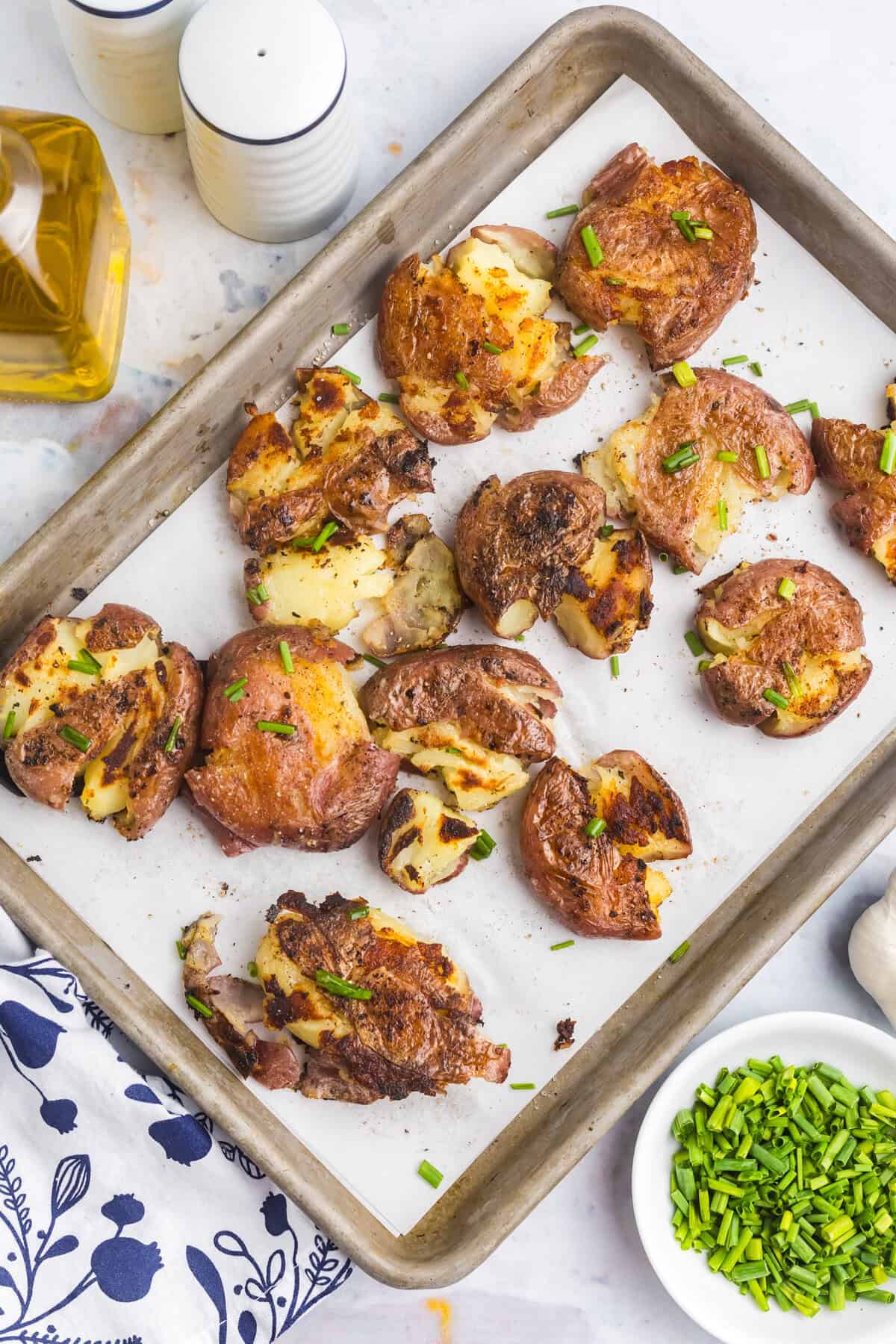Blackstone Smashed Potatoes arranged on parchment lined baking sheet