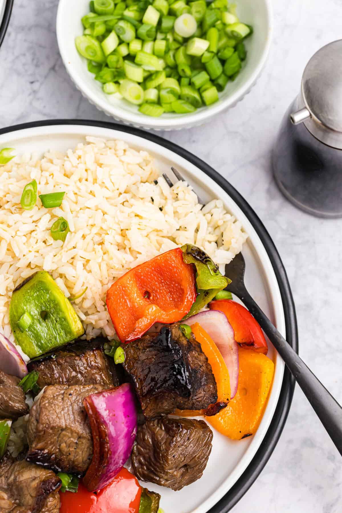 Blackstone Beef Kabobs off the stick with a side of white rice on dinner plate