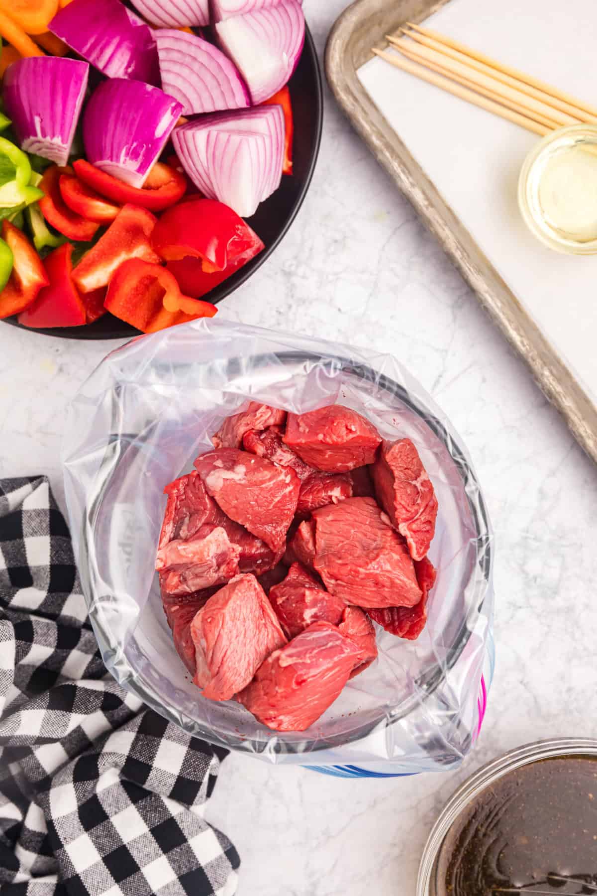 Cubed sirloin steak in ziplock bag lined glass jar for Blackstone Beef Kabobs recipe