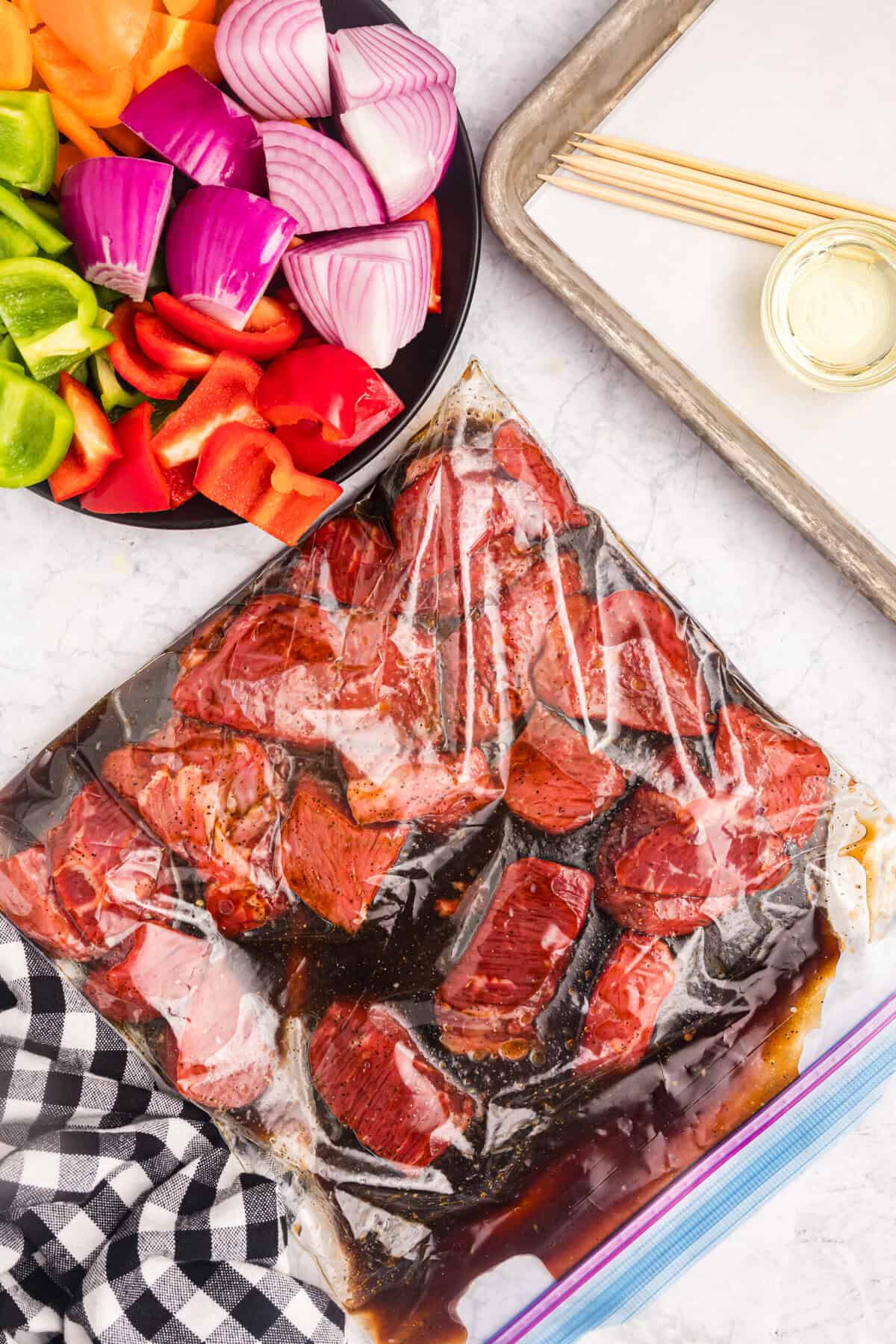 Tossing cubed sirloin steak and marinade in zip lock gallon bag for Blackstone Beef Kabobs