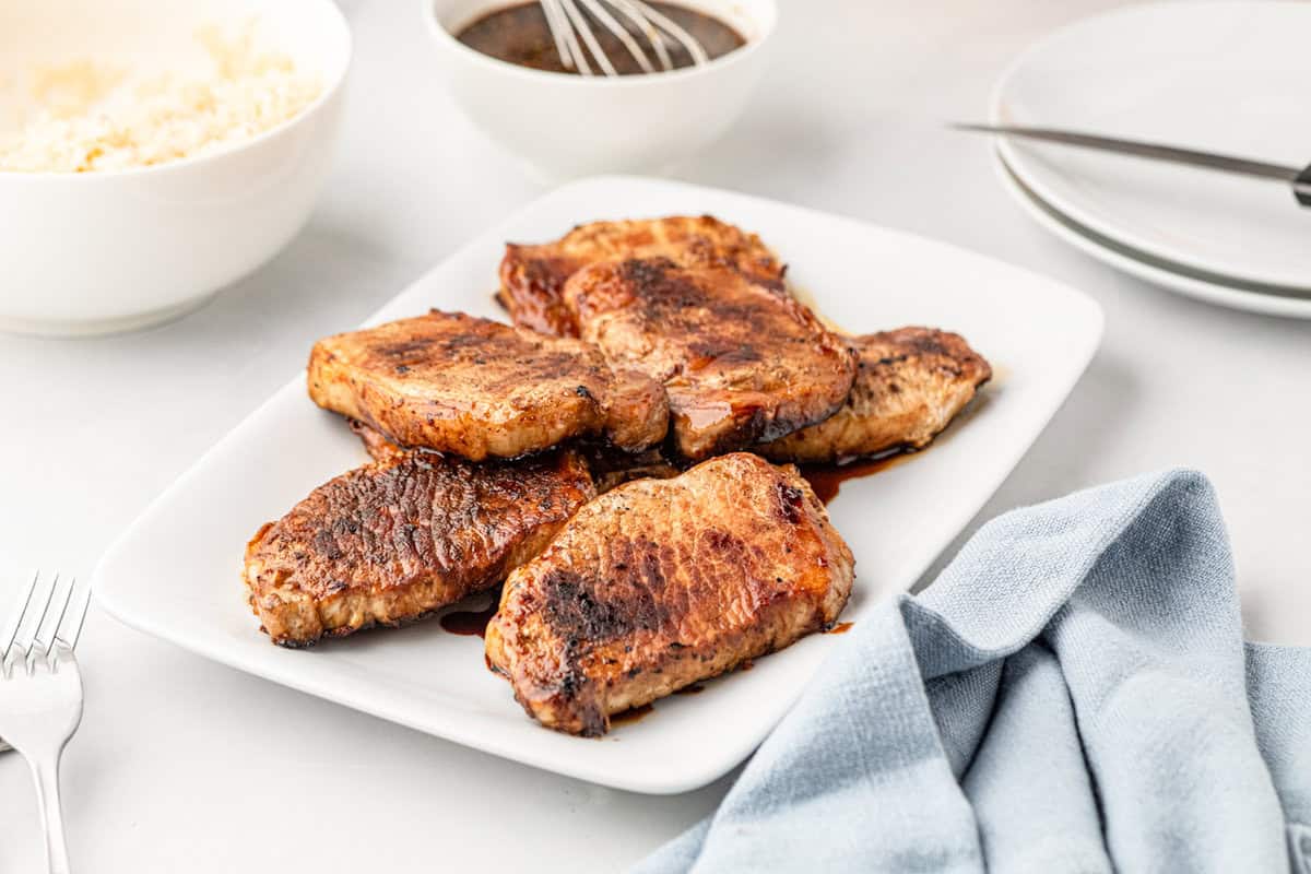 Grilled Honey Garlic Pork Chops layered on white serving plate