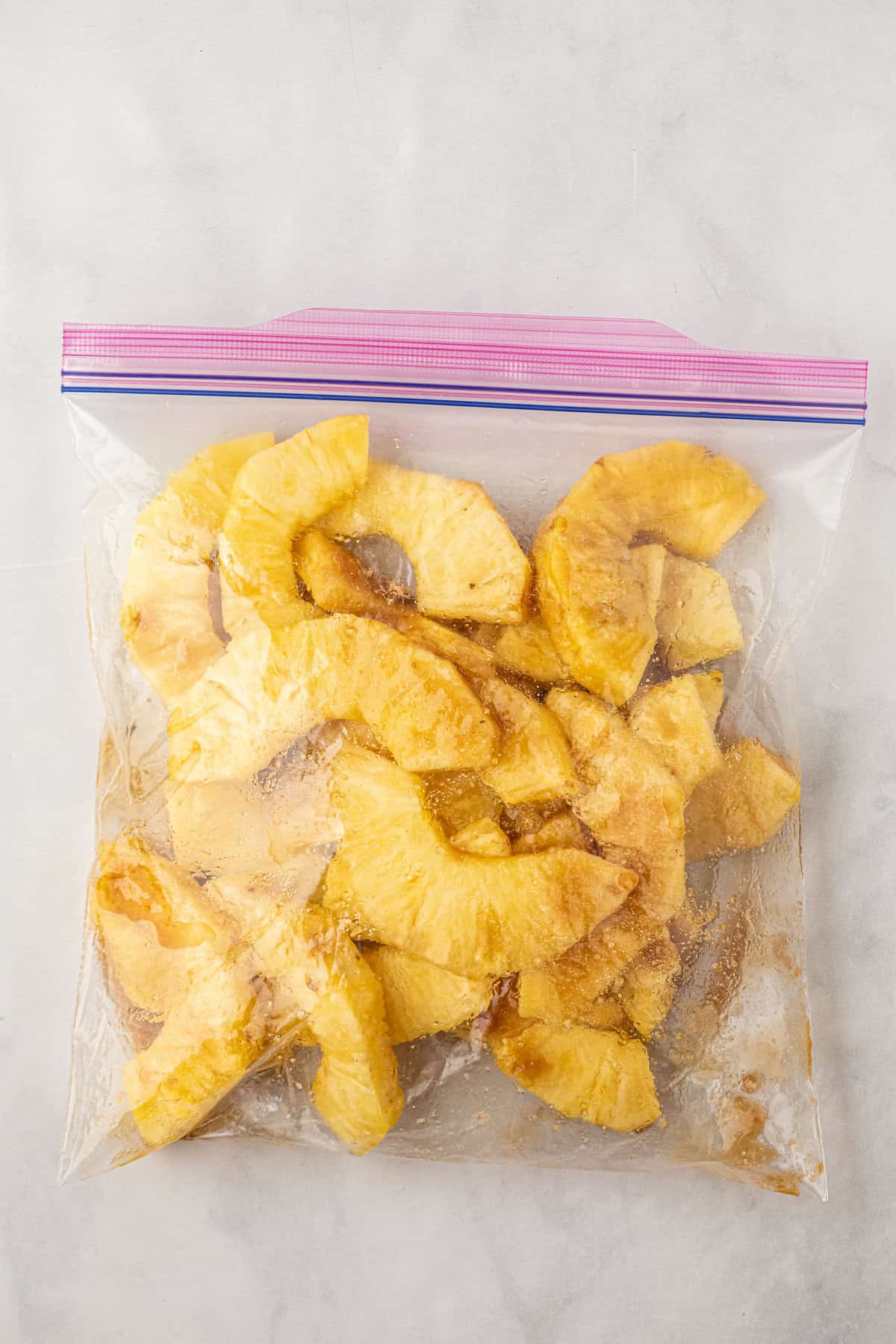 Pineapple pieces tossed in brown sugar in zip lock bag for Grilled Pineapple recipe