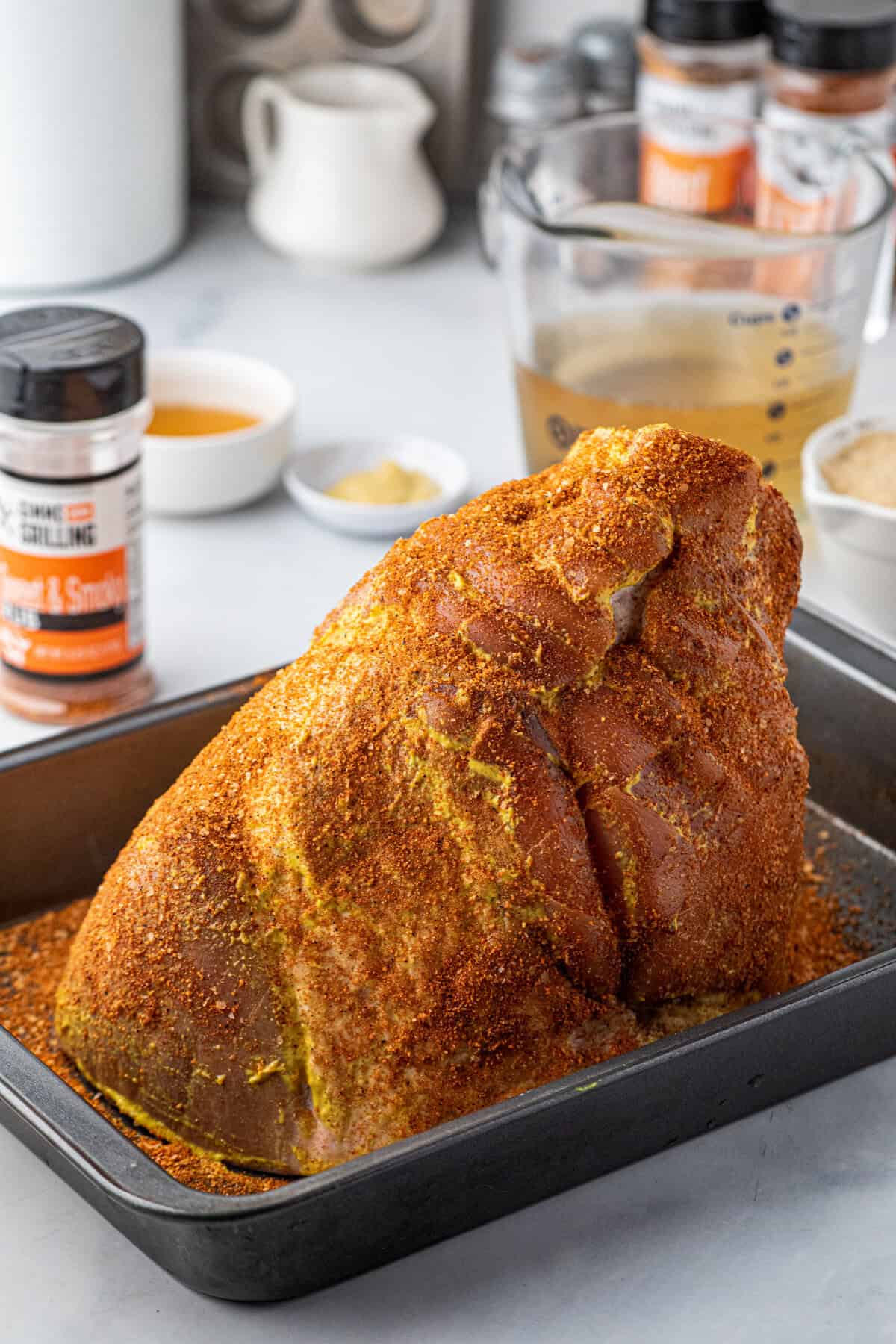 Coating the whole ham with Sweet & Smoky rub in shallow baking dish for Pulled Pork Ham recipe