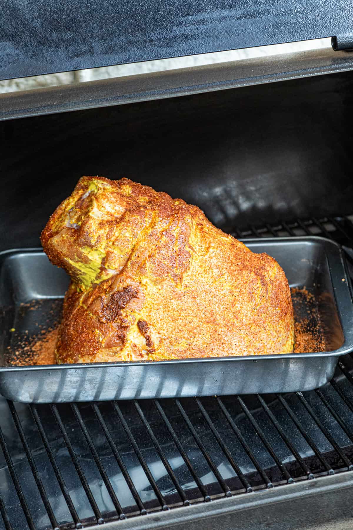 Grilling seasoned ham in shallow baking dish for Pulled Pork Ham recipe