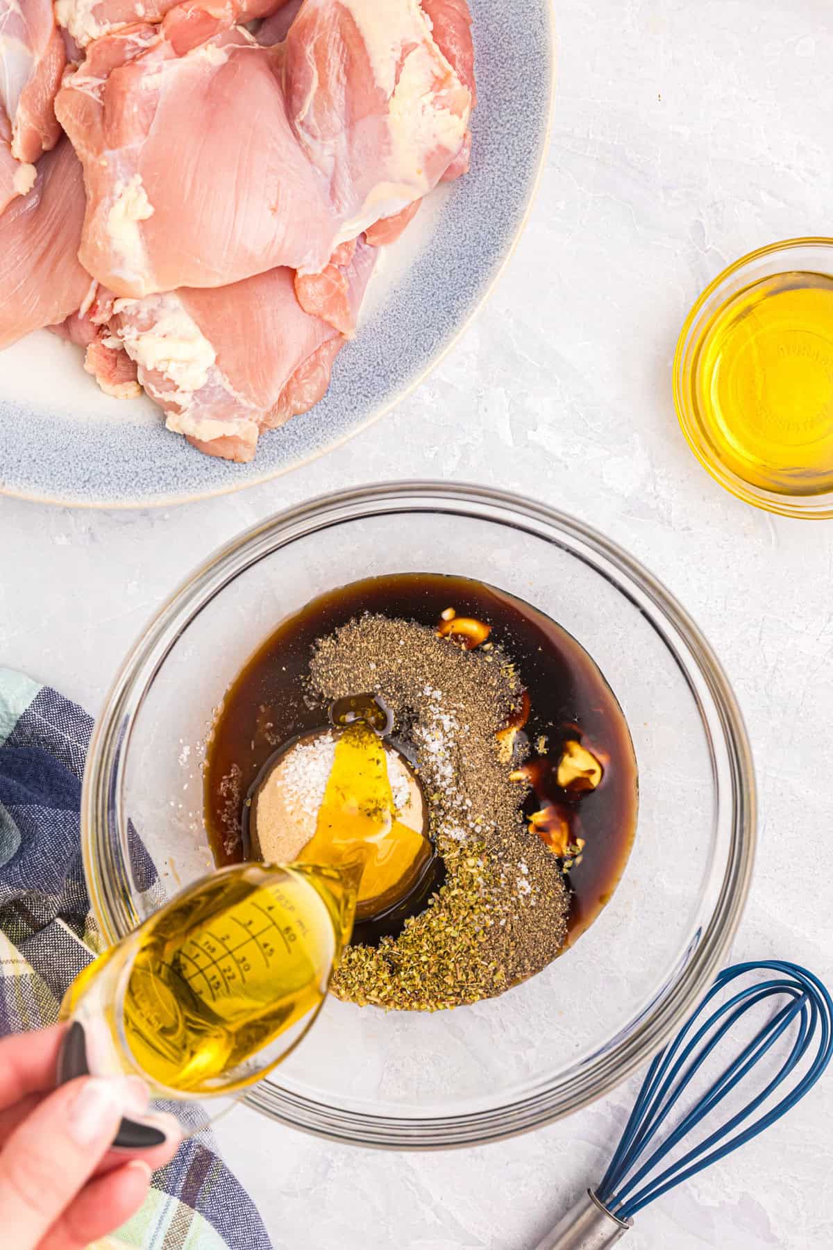 Pouring Blackstone Chicken Thighs marinade in small mixing bowl
