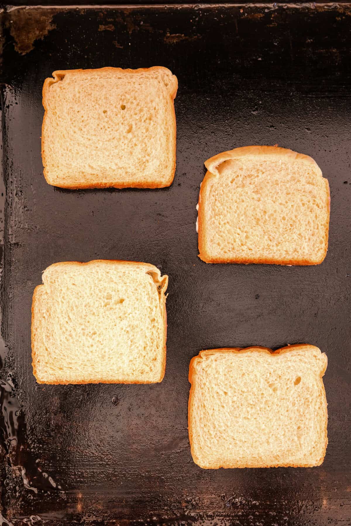 Mayonaise side of bread faced down on Blackstone griddle for Blackstone Grilled Cheese recipe