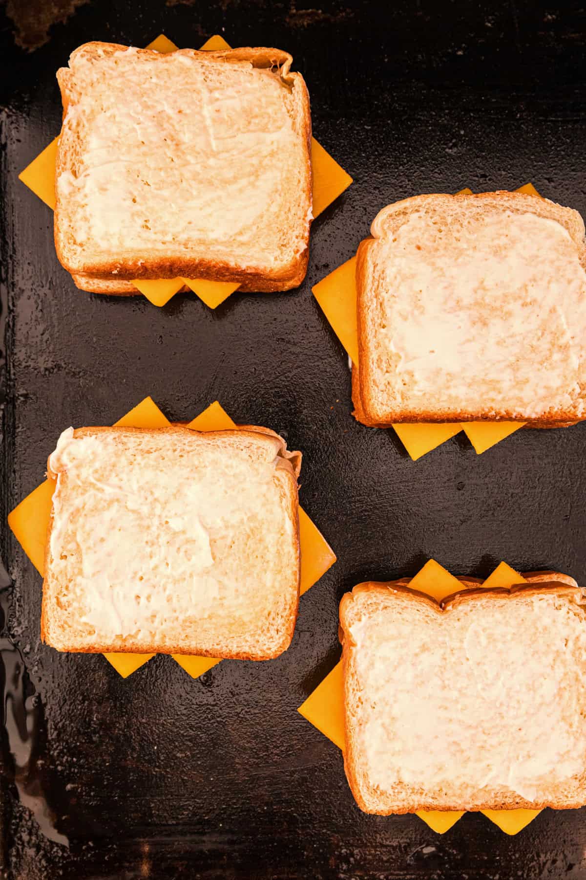 Finishing out Blackstone Grilled Cheese stack with another piece of Mayonaise spread on bread pieces