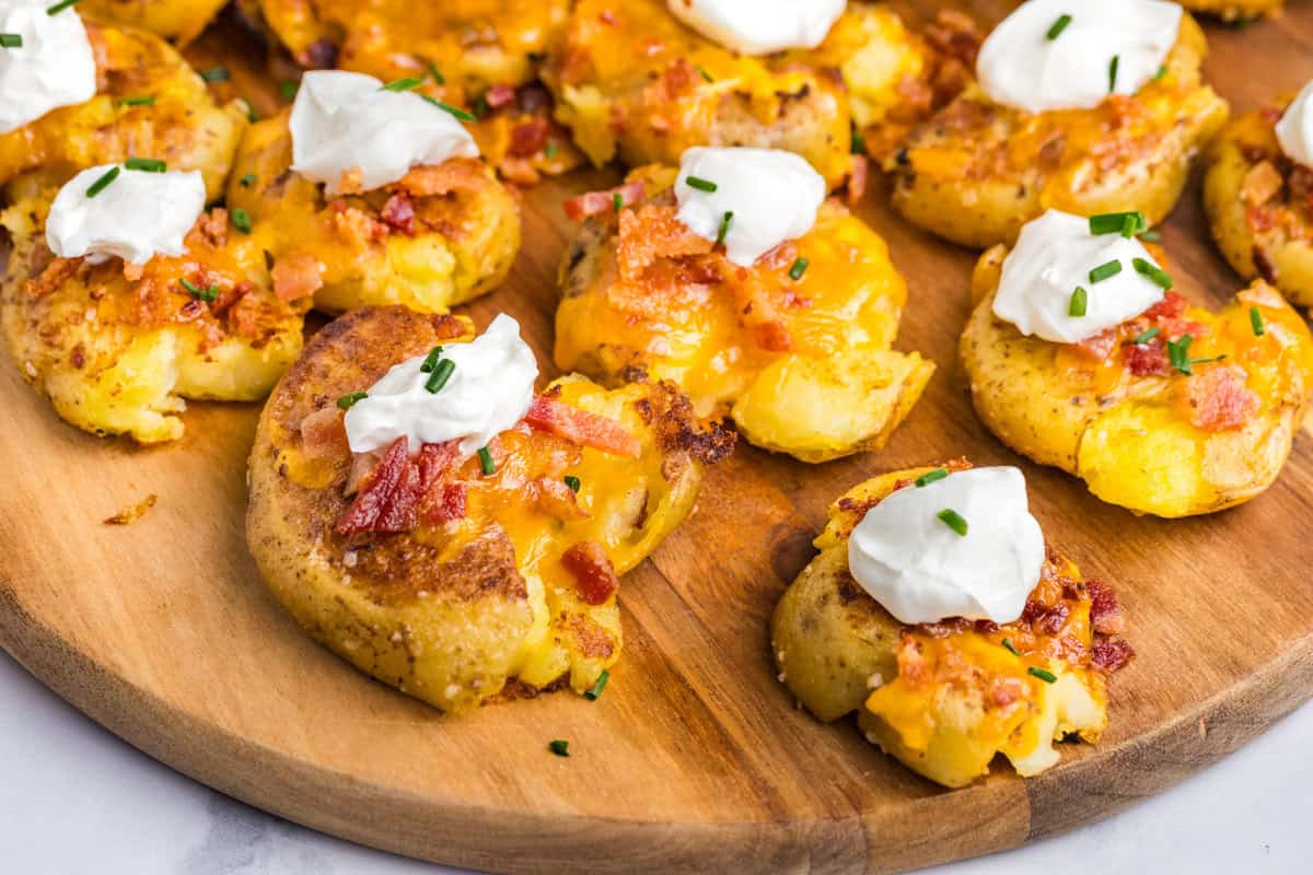 Blackstone Loaded Smashed Potatoes arranged on wooden serving platter 
