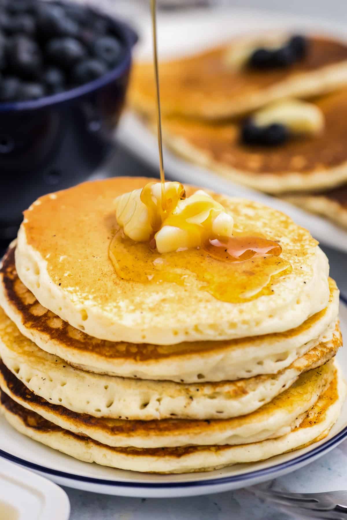 Plate of stacked Blackstone Buttermilk Pancakes with butter and syrup