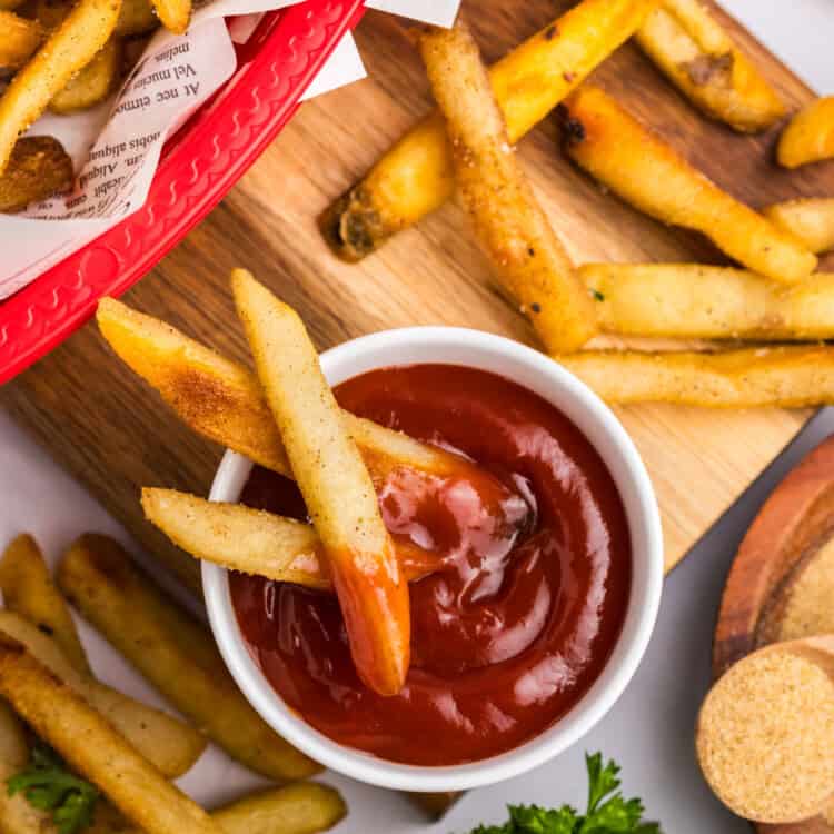 Blackstone French Fries spread about in baskets on tray with ketchup to dip