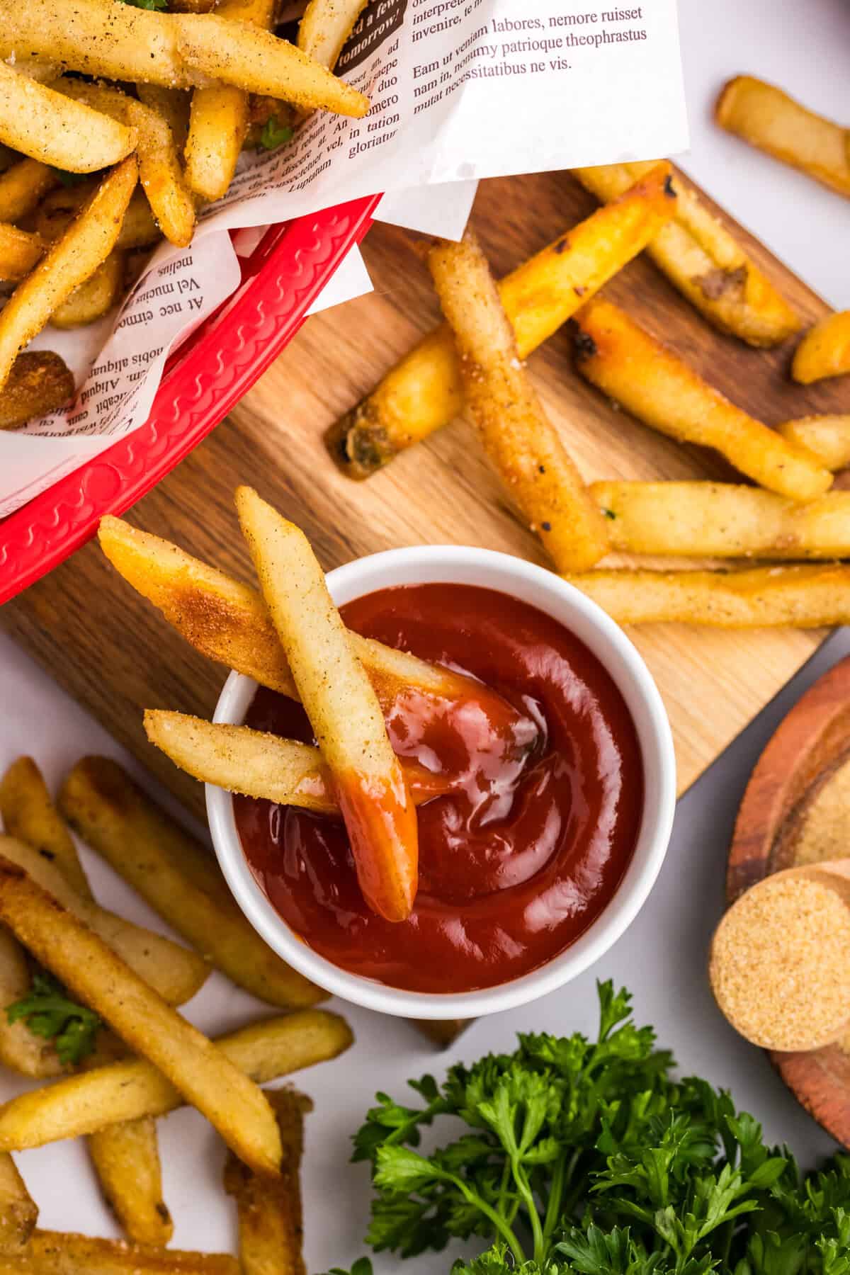Blackstone French Fries spread about in baskets on tray with ketchup to dip