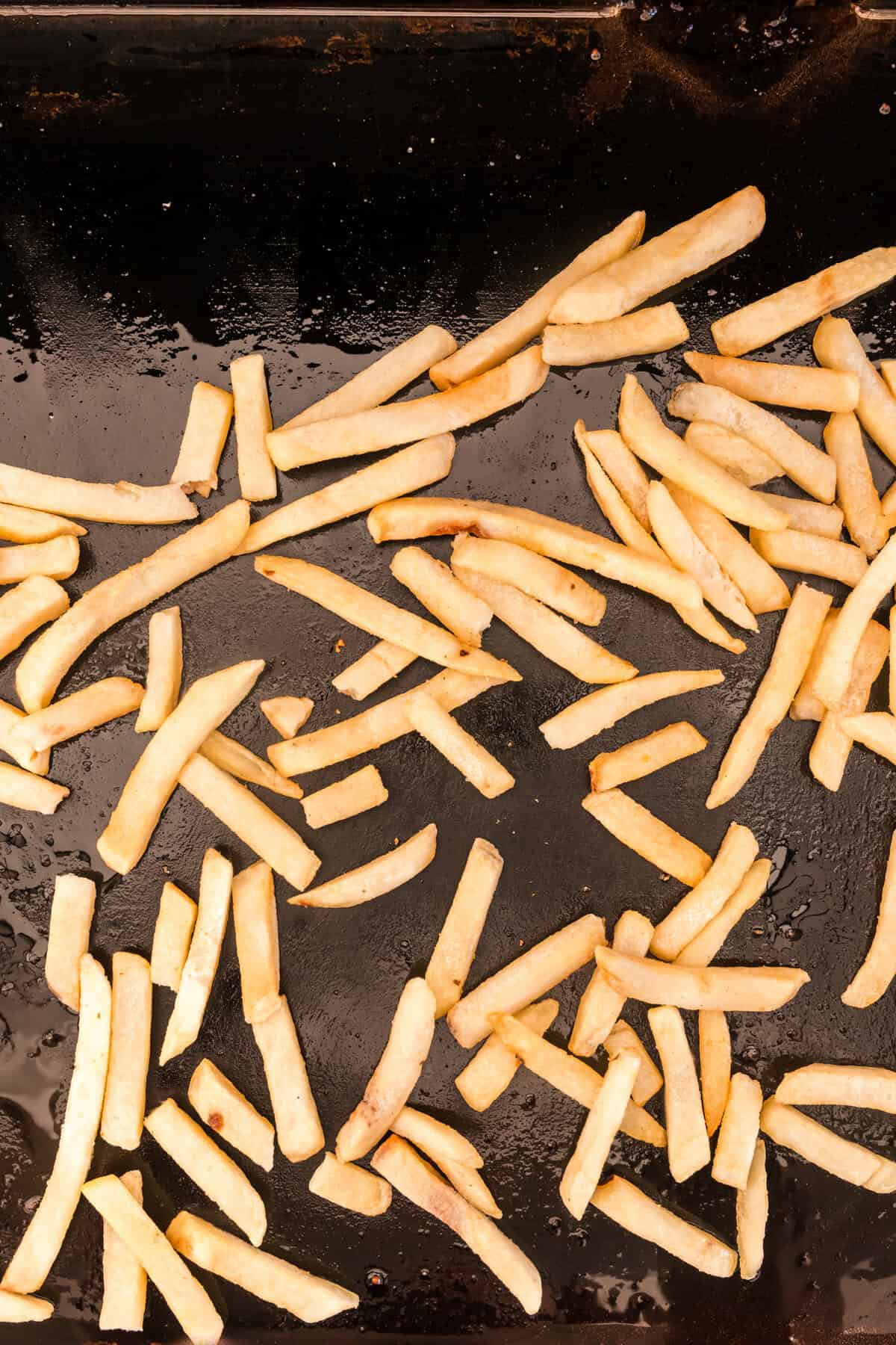 Slightly frozen french fries on Blackstone griddle for Blackstone French Fries recipe