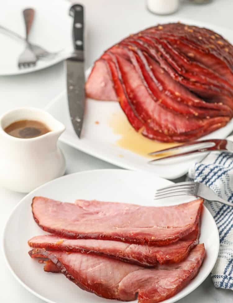 Double Smoked Ham with Glaze on serving plate with slices on white dinner plate
