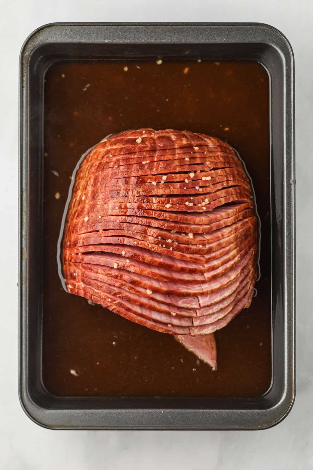 Glaze poured over ham in 9x13 baking dish for Double Smoked Ham with Glaze
