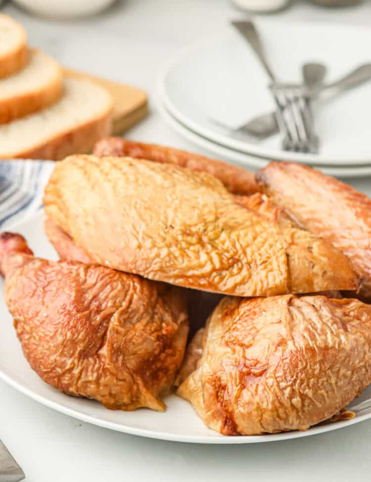 Partially cut up turkey on a white serving plate.