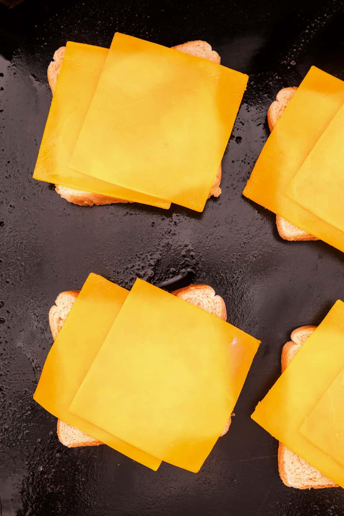 One slice of bread with two slices of cheese on it on the Blackstone.