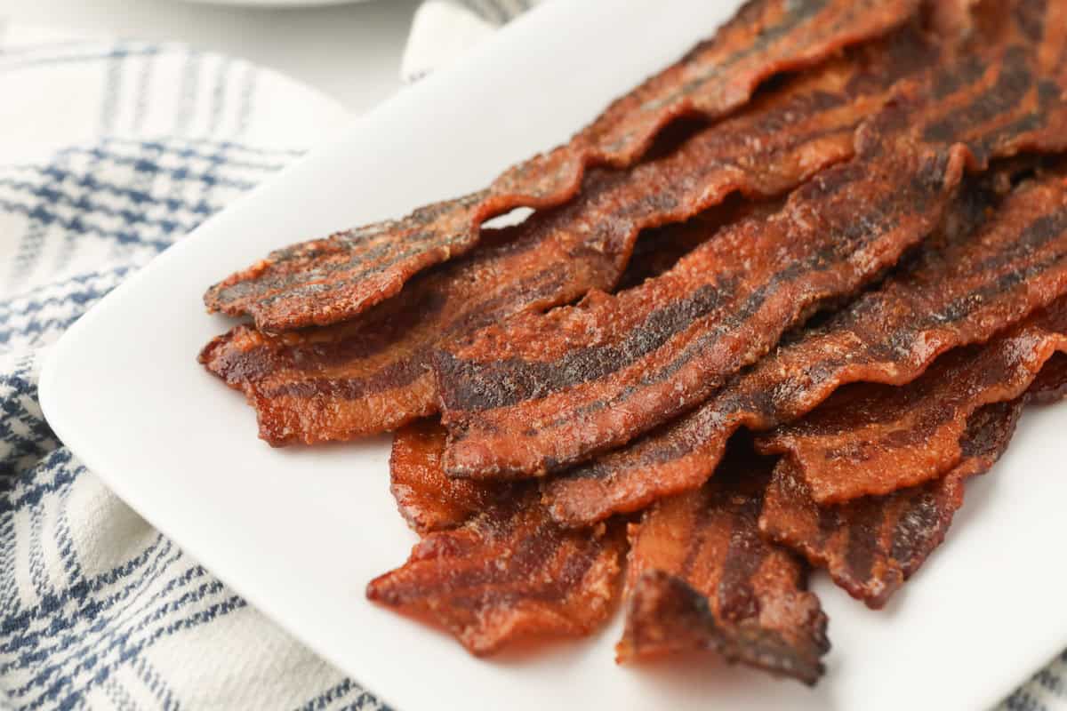 Close up image of completed Smoked Candied Bacon on a white plate.