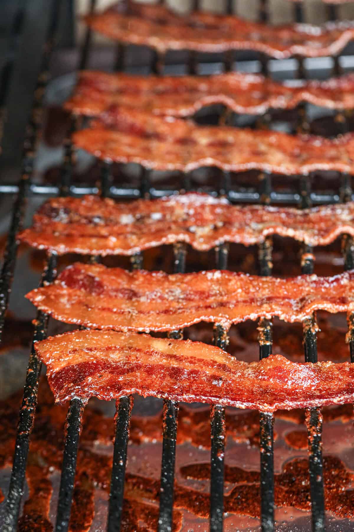 Close up image of Candied Smoked Bacon cooking on the smoker.