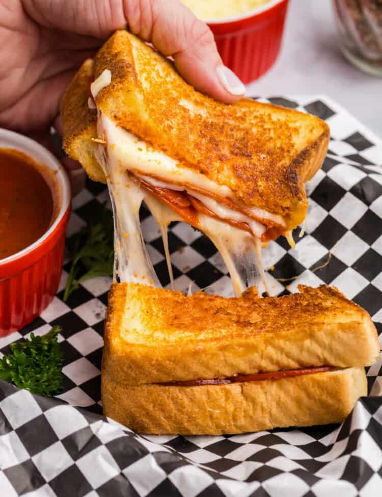 Picture of a completed Blackstone Pizza Grilled Cheese being pulled apart with cheese stringing between the two halves.