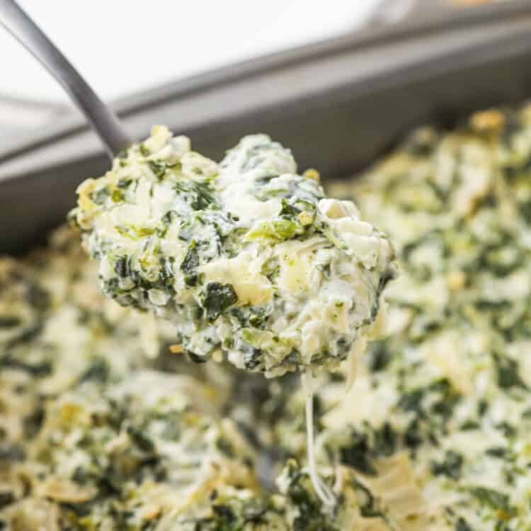 Cooked Smoked Spinach Artichoke Dip being scooped up by metal spoon.