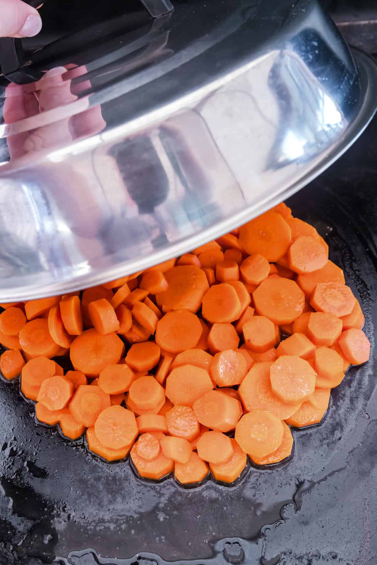 Overhead picture of food cover being put onto carrots.