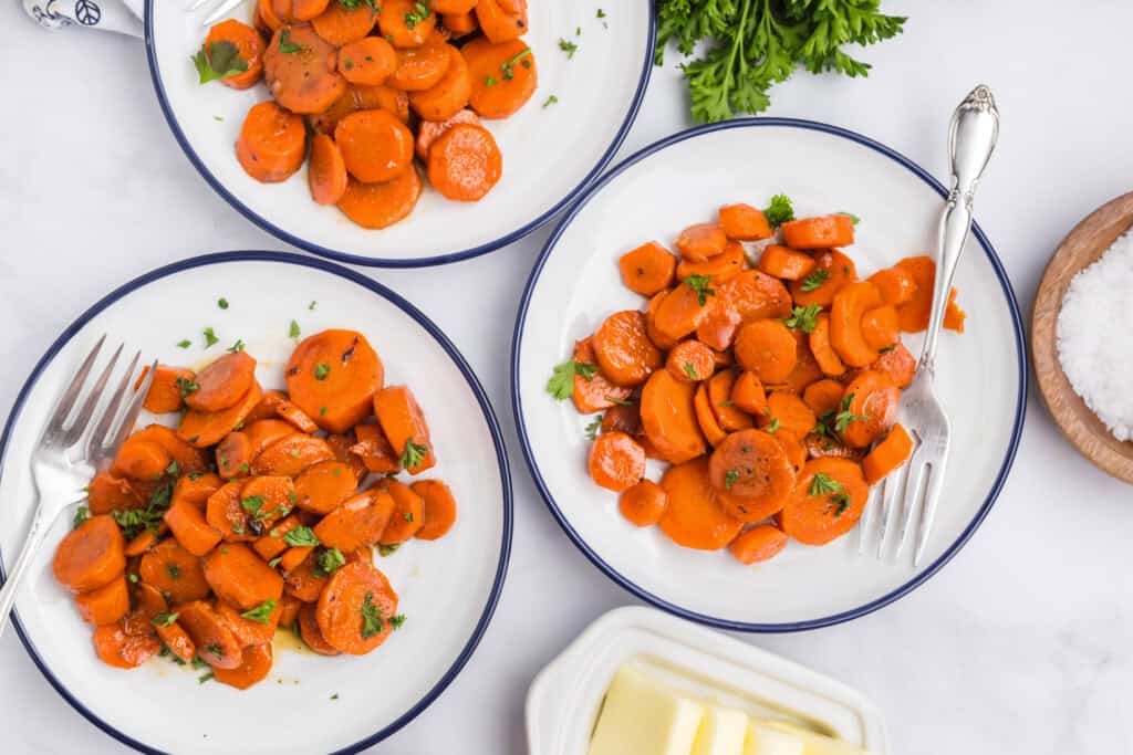 Overhead picture of three plates of Blackstone Glazed Carrots.