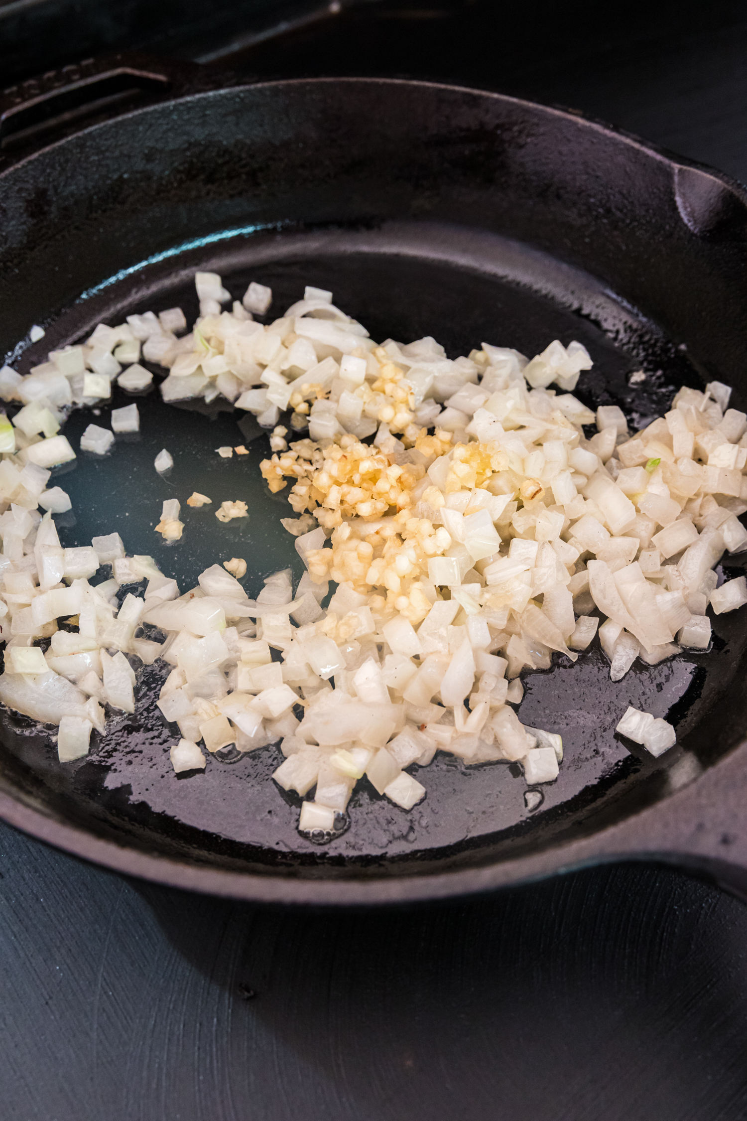 Close up picture of cooked onions in a cast iron skillet.