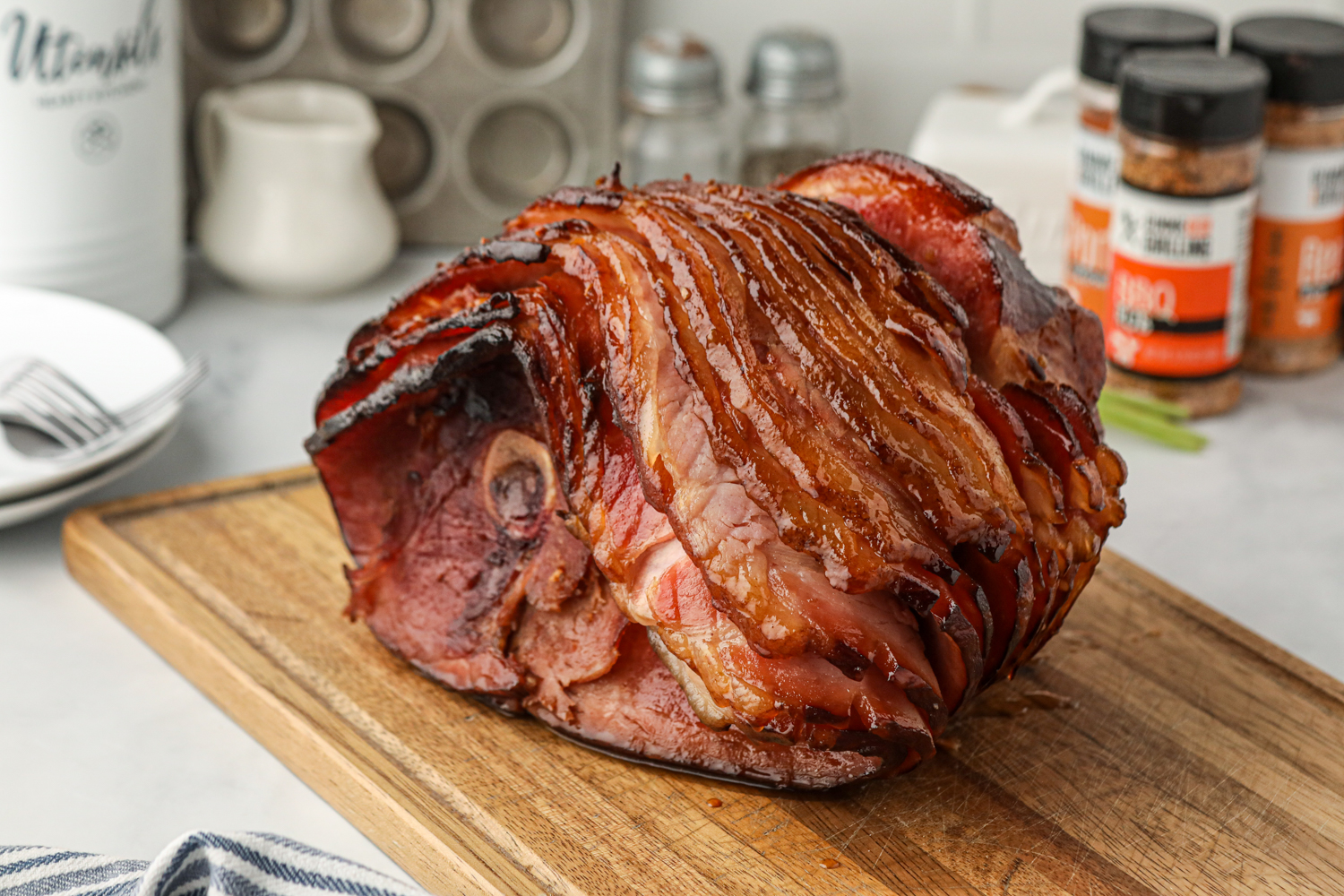 This grilled ham looks absolutely mouthwatering! The caramelization on the edges, the glistening glaze, and the deep smoky char make it so visually appealing. The setting is also beautifully styled, with the rustic cutting board and the seasonings in the background adding a cozy, home-cooked feel. This is the kind of dish that would steal the show at any gathering!