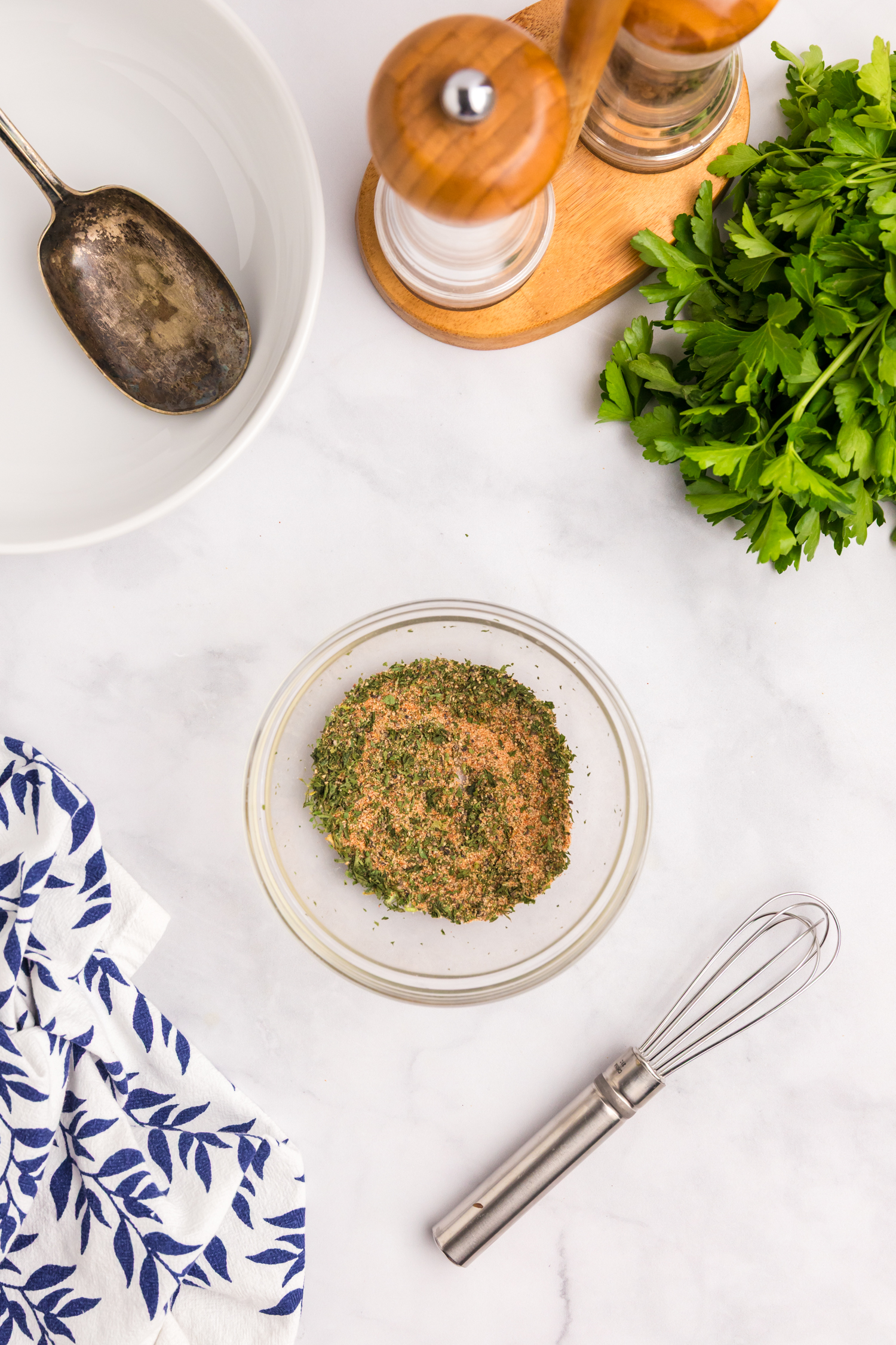 Blended breakfast potato seasoning mix in a glass bowl with whisk nearby.