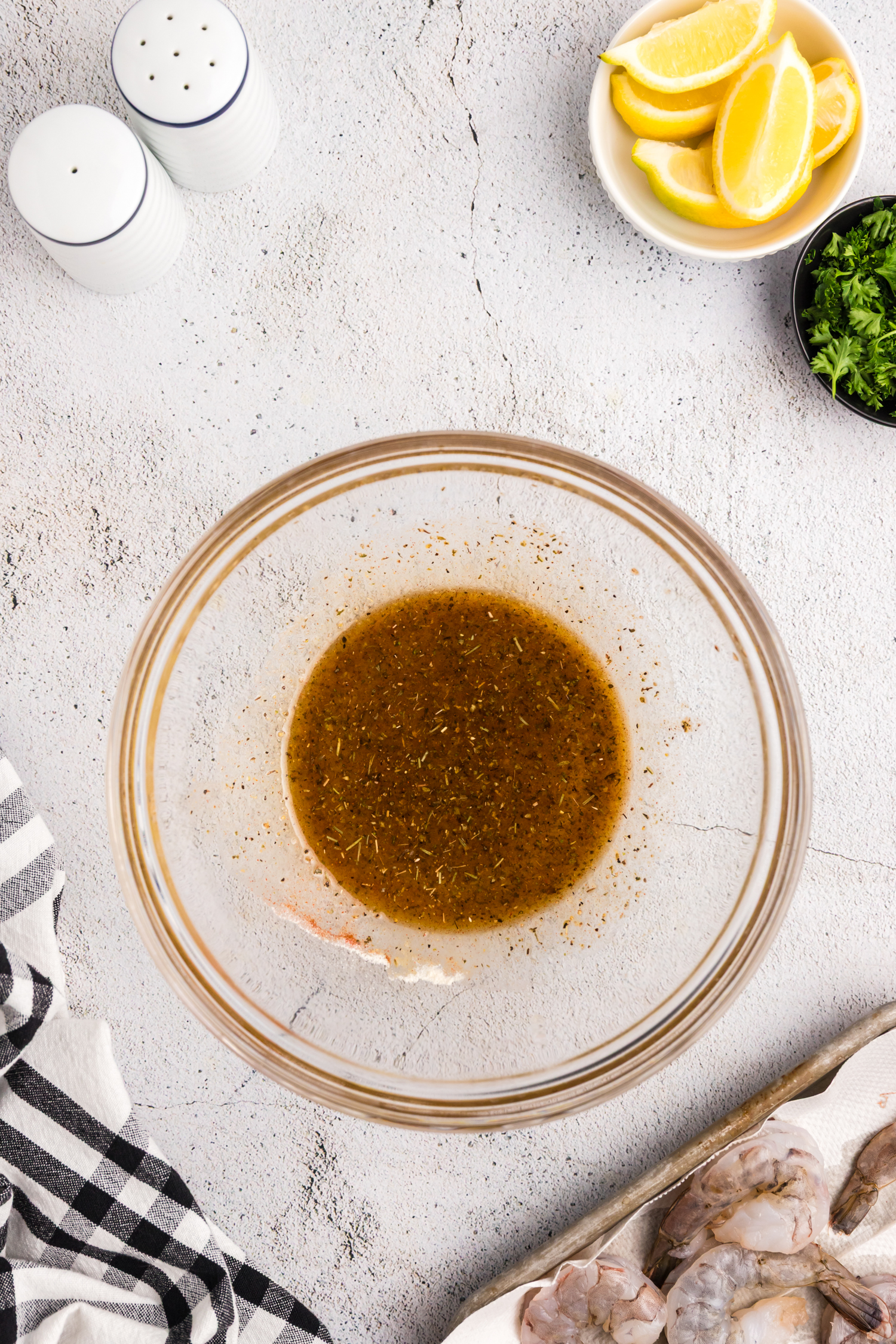 Seasoning mixture blended into a marinade inside a glass mixing bowl.