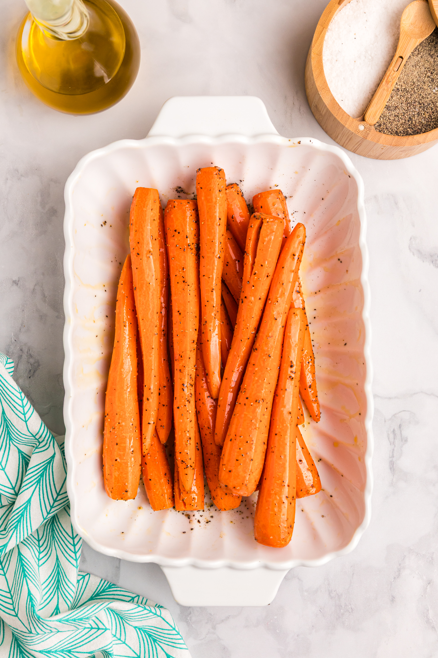 Seasoned carrots tossed to evenly coat with oil, salt, and pepper.