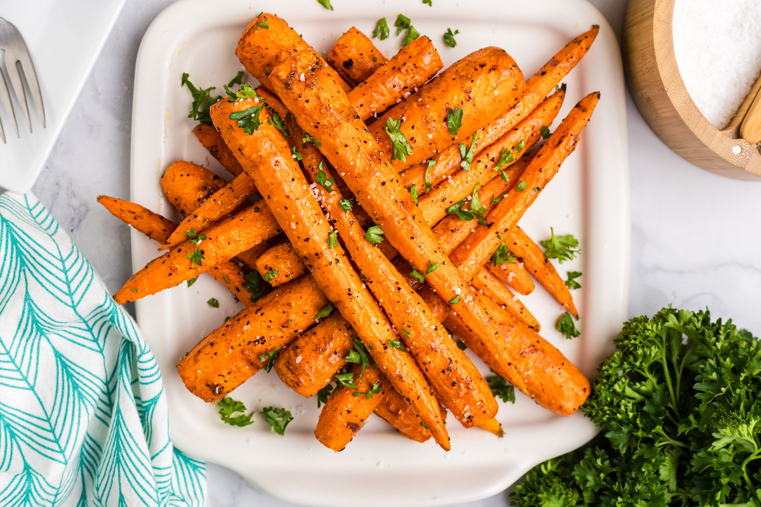 Zoomed-in view highlighting texture and seasoning on grilled carrots with fresh parsley on the side.