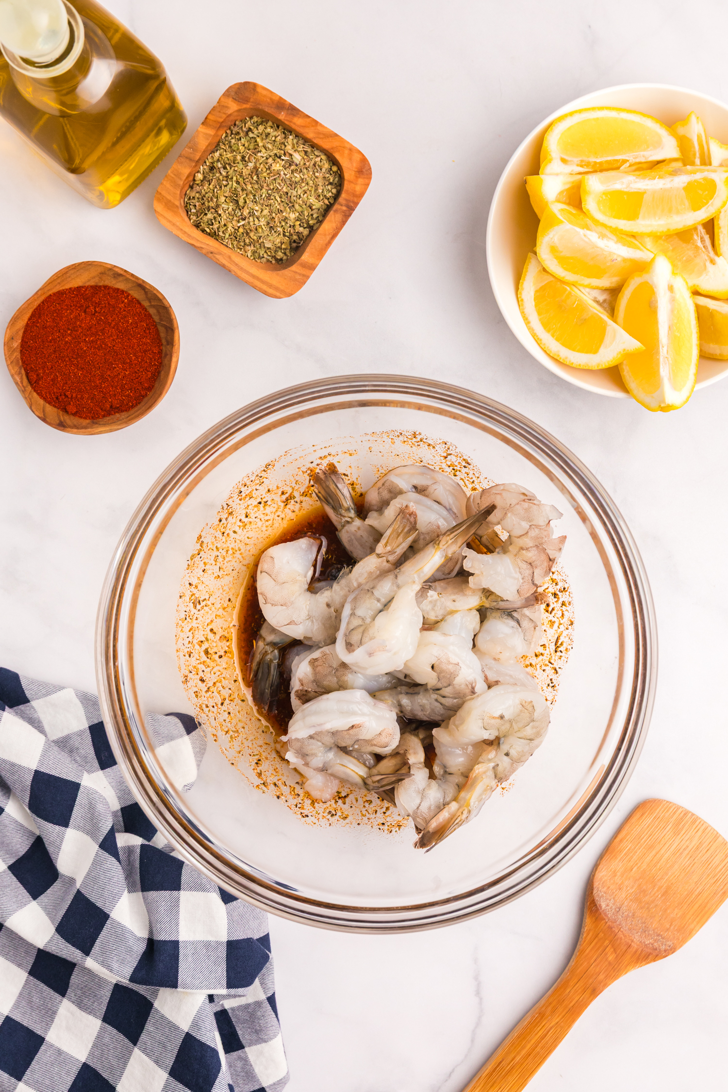 Raw shrimp added to the bowl with the marinade, ready to be tossed.