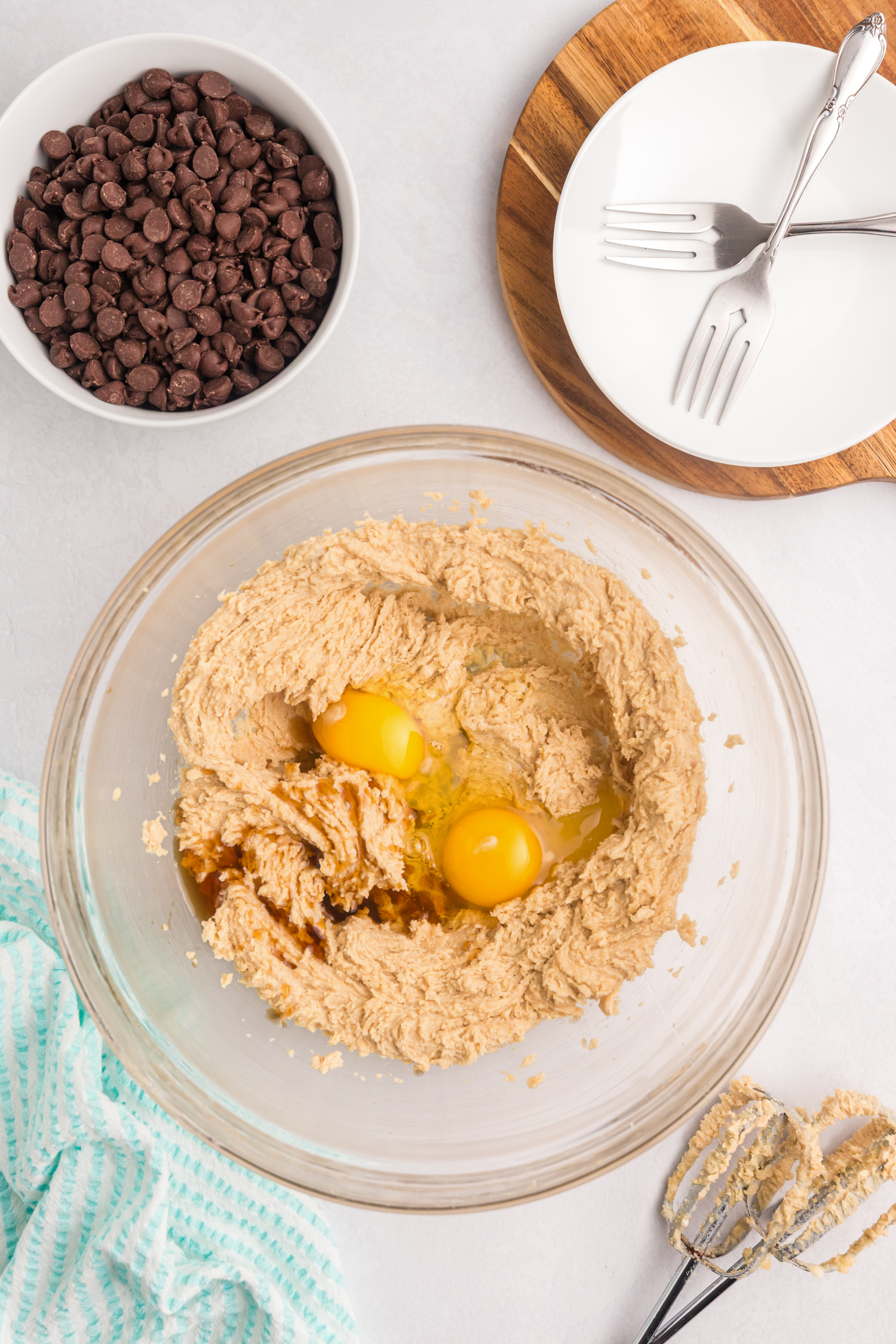 The butter and sugar mixture has been creamed, and two raw eggs and vanilla extract have been added to the bowl but not yet mixed.
