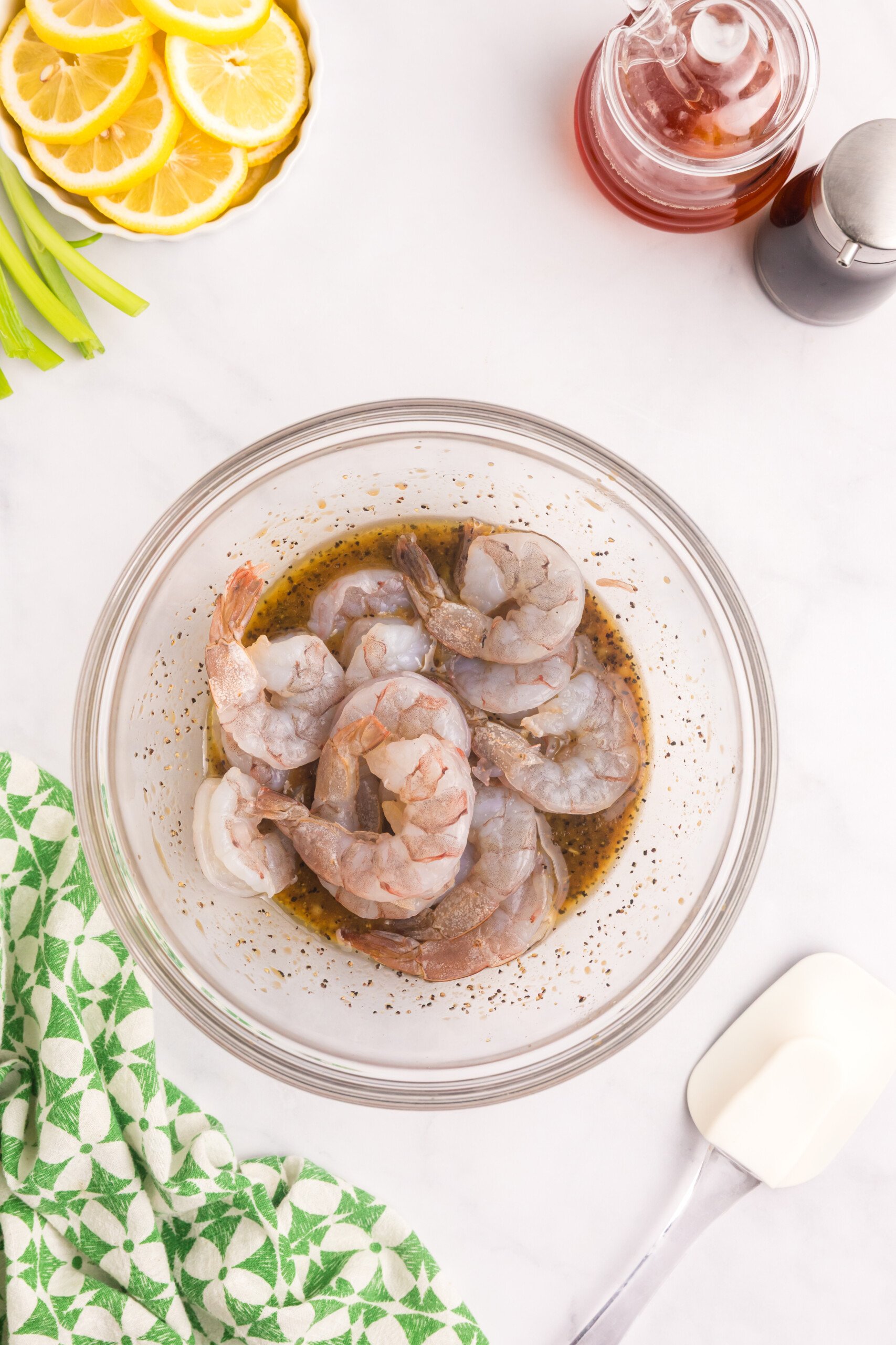 Raw shrimp added into the prepared marinade in the bowl.