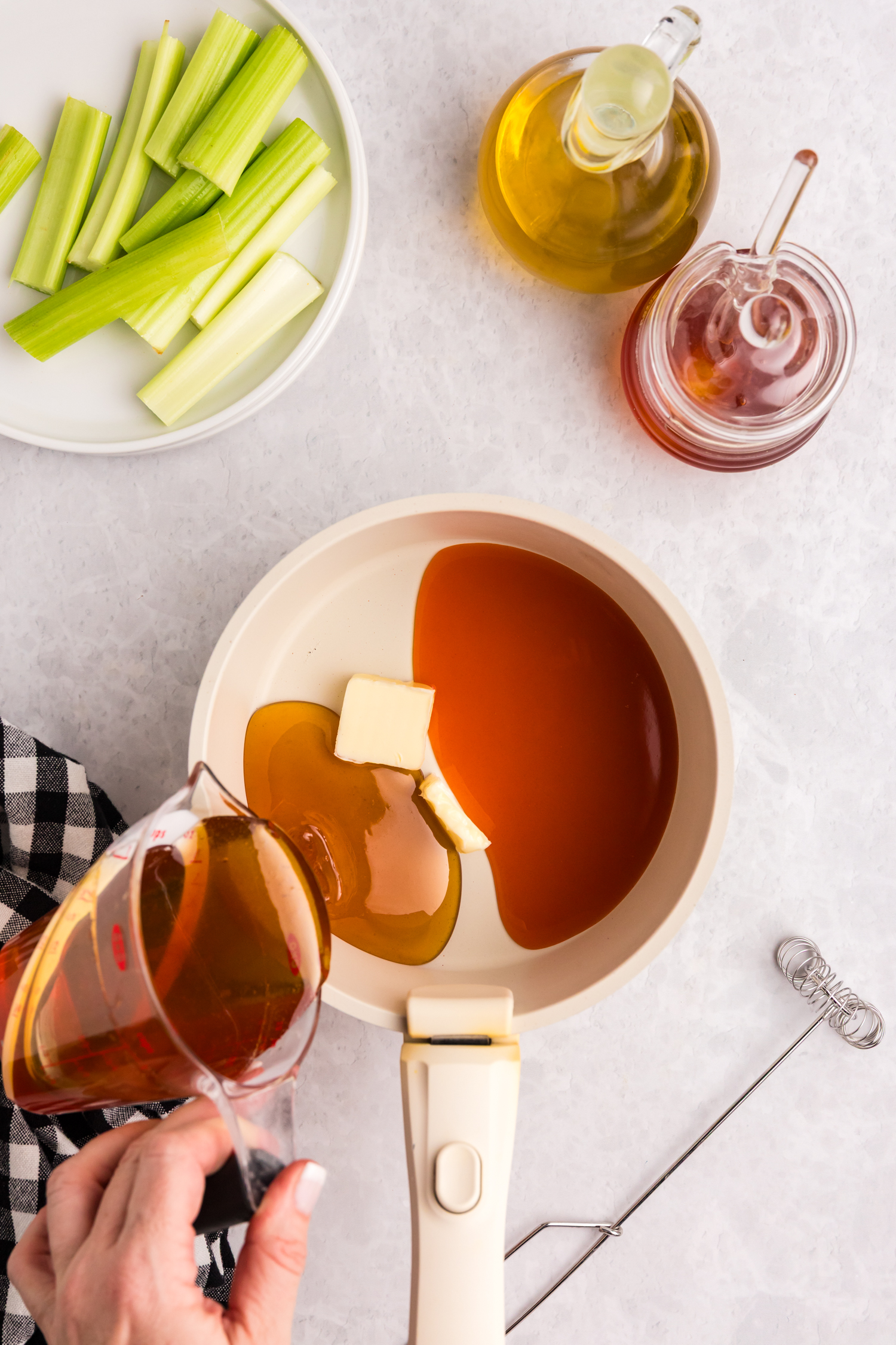 Sauce preparation: butter, hot sauce, and honey being poured into a saucepan.