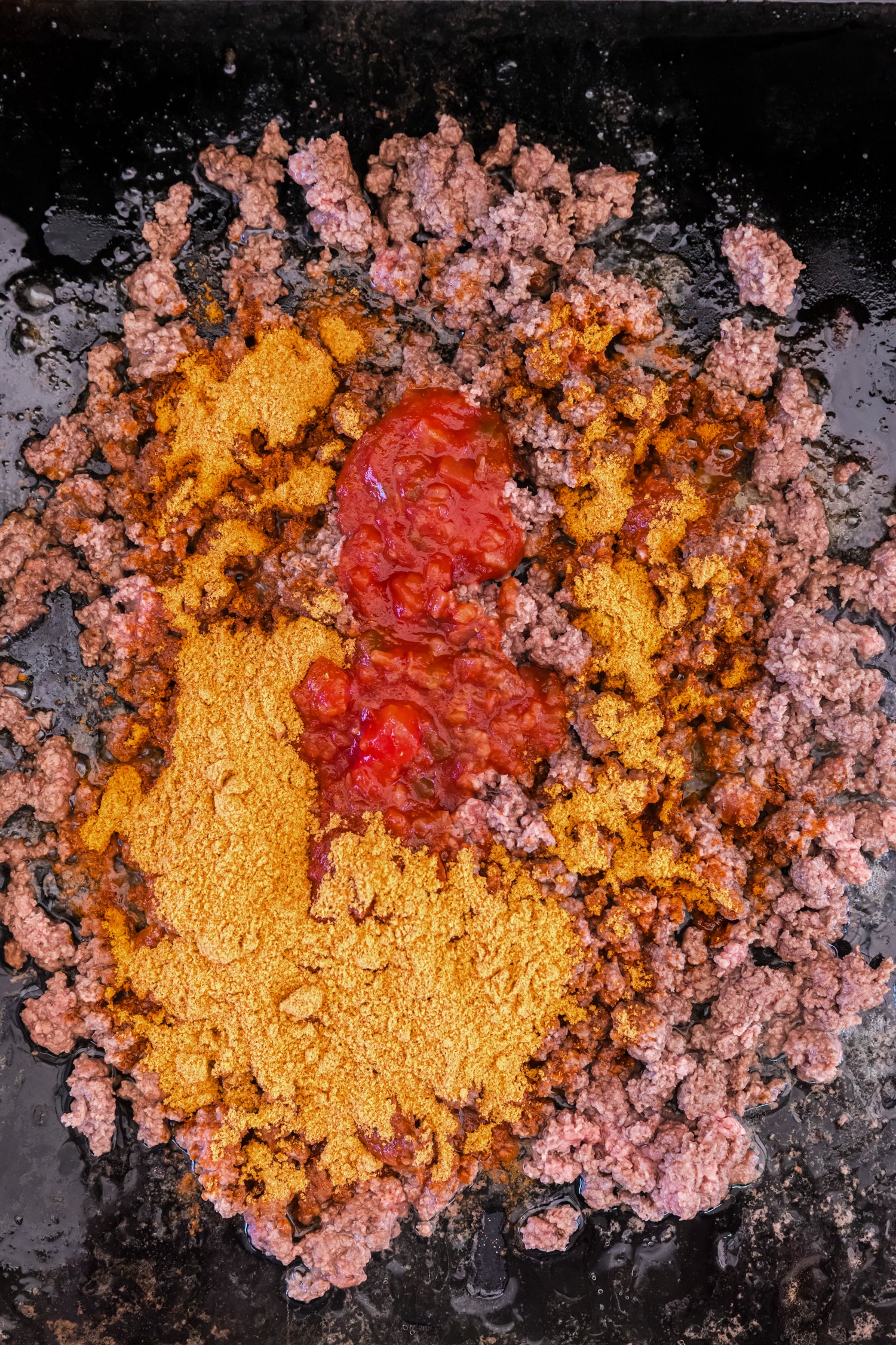 A flour tortilla warming on a griddle with light brown toasted spots.