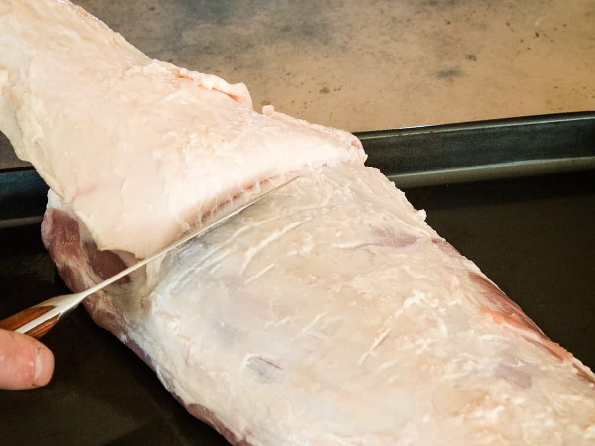 Cutting fat cap off of a pork loin